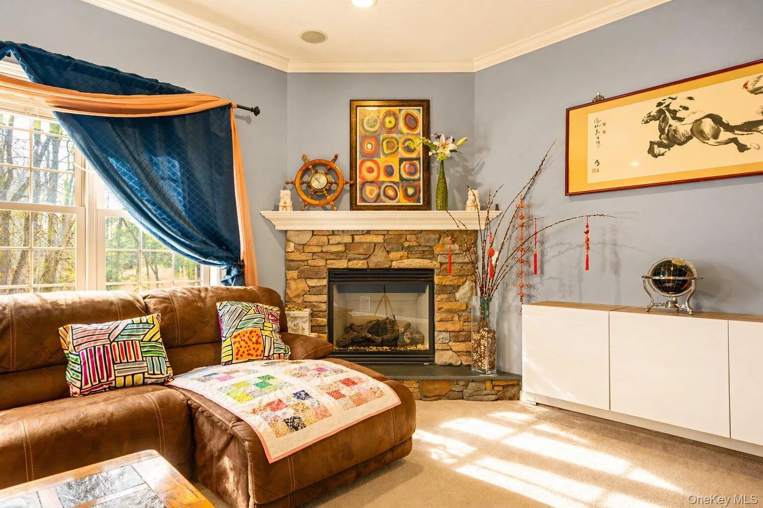 Stone-clad fireplace with a dark-framed insert, corner placement, and a white mantel Stone-clad fireplace with a dark-framed insert, corner placement, and a white mantel