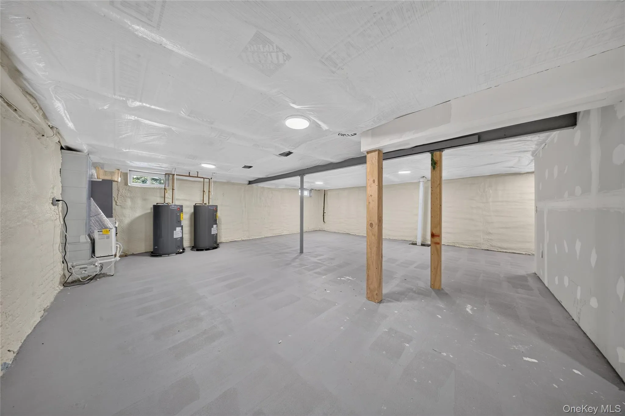 Unfinished lower level with concrete flooring, exposed structural beams, and recessed lighting Unfinished lower level with concrete flooring, exposed structural beams, and recessed lighting