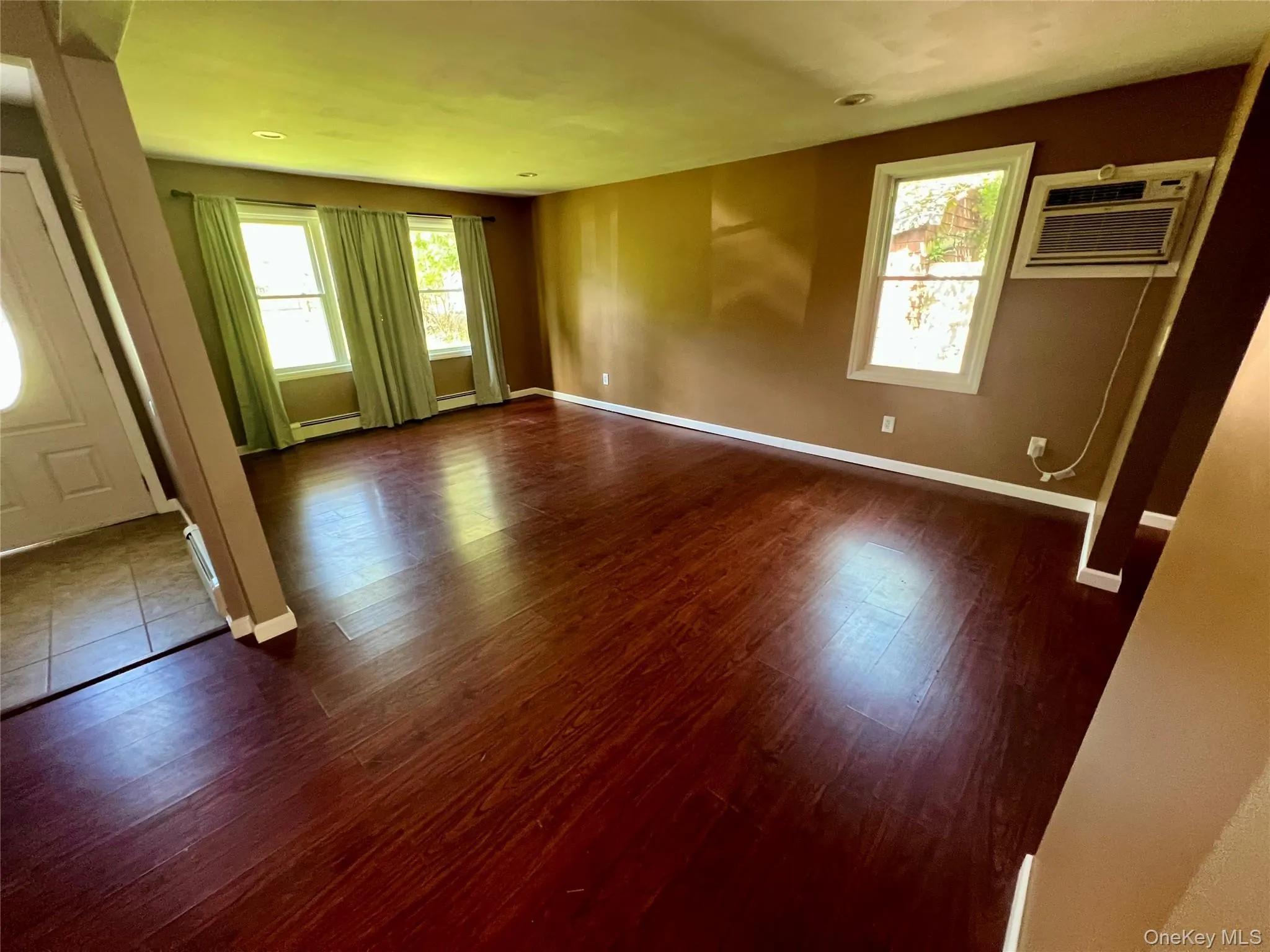 Large living room with multiple windows and an open layout. Large living room with multiple windows and an open layout.