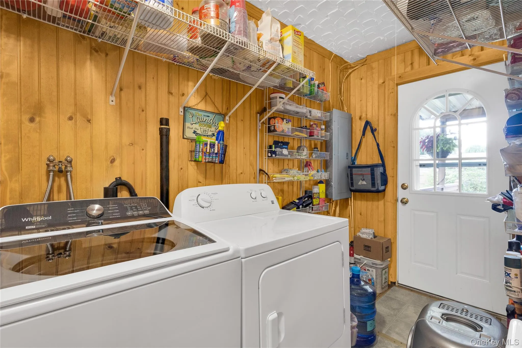 Wood paneling throughout, white appliances, wire shelving, white exterior door with arched window Wood paneling throughout, white appliances, wire shelving, white exterior door with arched window