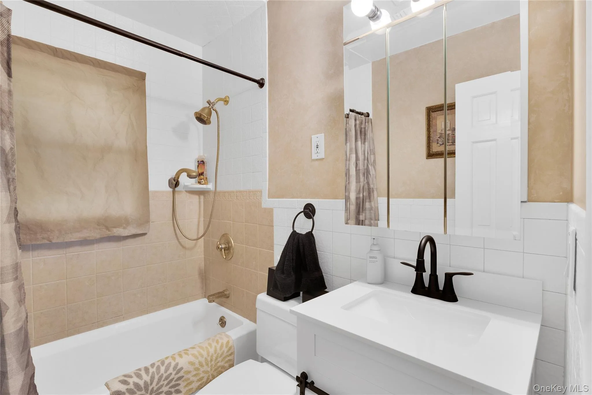 White bathtub with brass-finish shower fixtures White bathtub with brass-finish shower fixtures