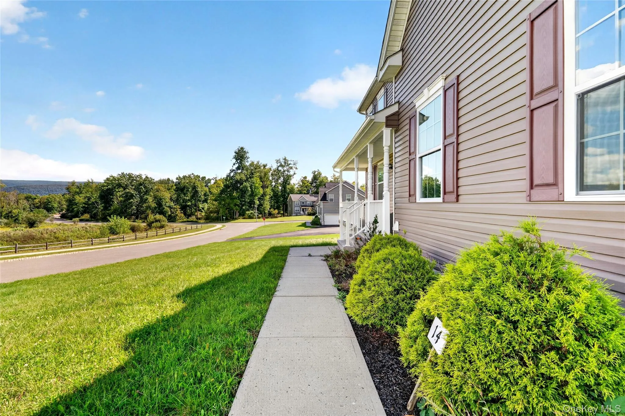 Siding exterior with decorative shutters, covered porch with white railings, concrete walkway, and manicured shrubs Siding exterior with decorative shutters, covered porch with white railings, concrete walkway, and manicured shrubs