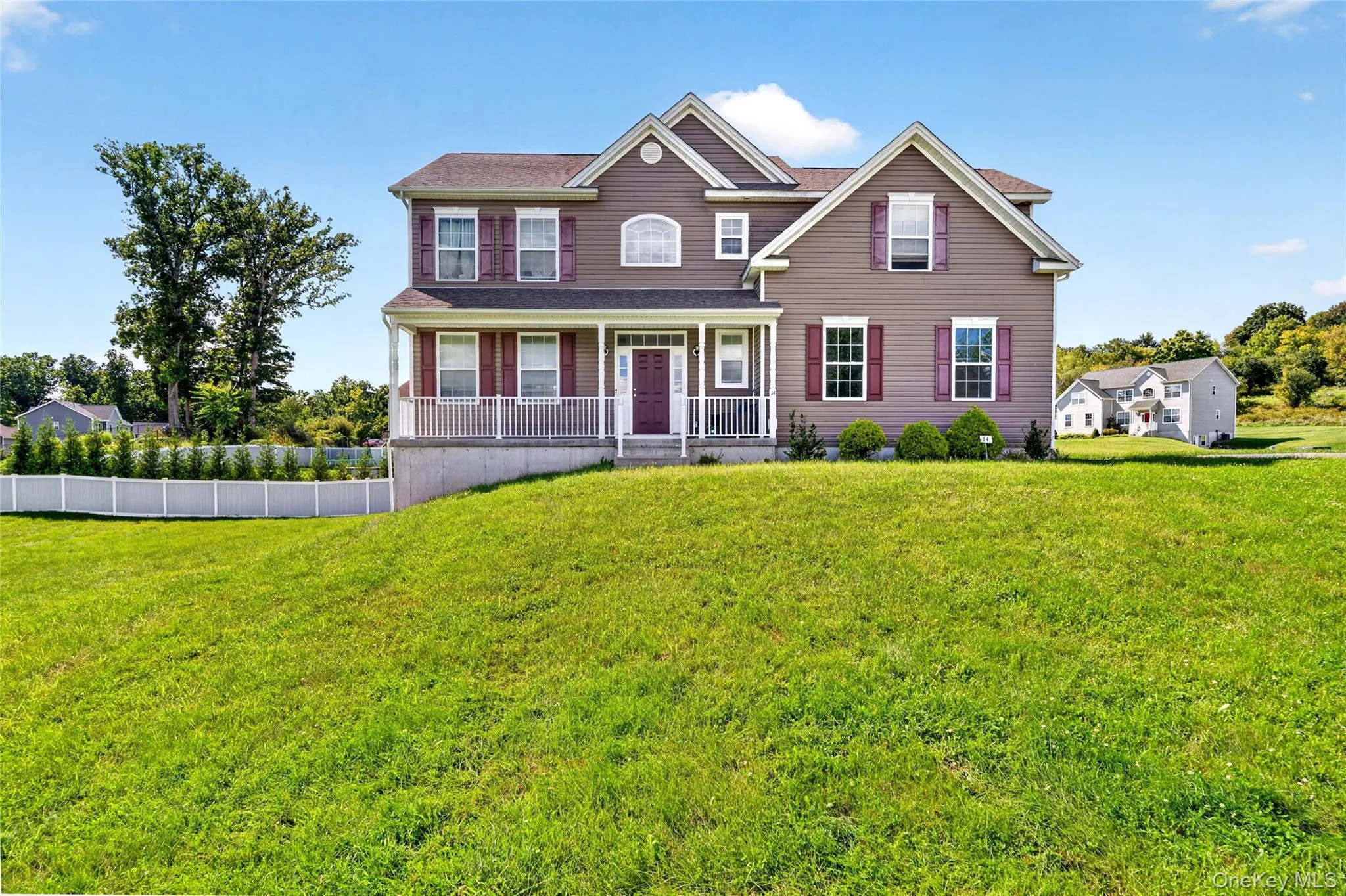 Two-story residence with a covered front porch featuring white railings Two-story residence with a covered front porch featuring white railings