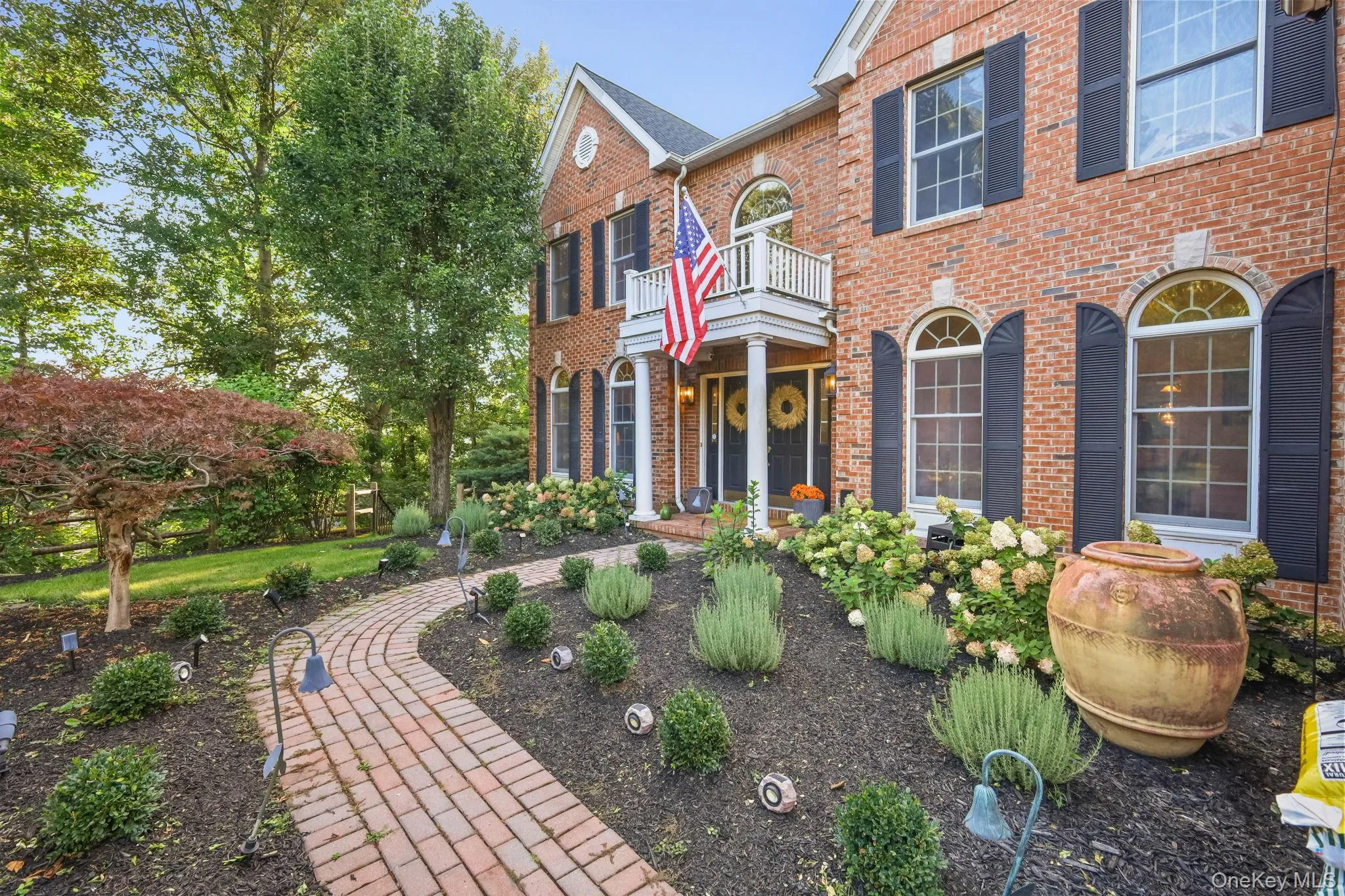 Specimen plantings and flowering shrubs frame the stone walkway of this stately colonial. Specimen plantings and flowering shrubs frame the stone walkway of this stately colonial.