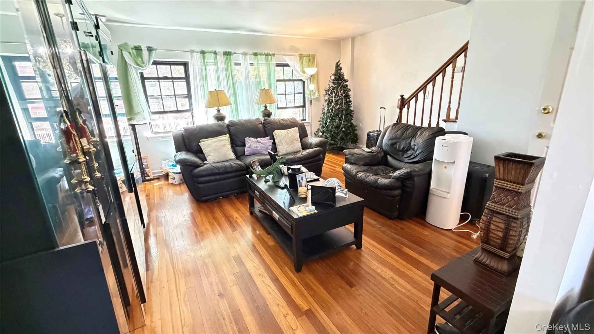 Hardwood flooring, painted walls, and a visible staircase with wooden handrails Hardwood flooring, painted walls, and a visible staircase with wooden handrails