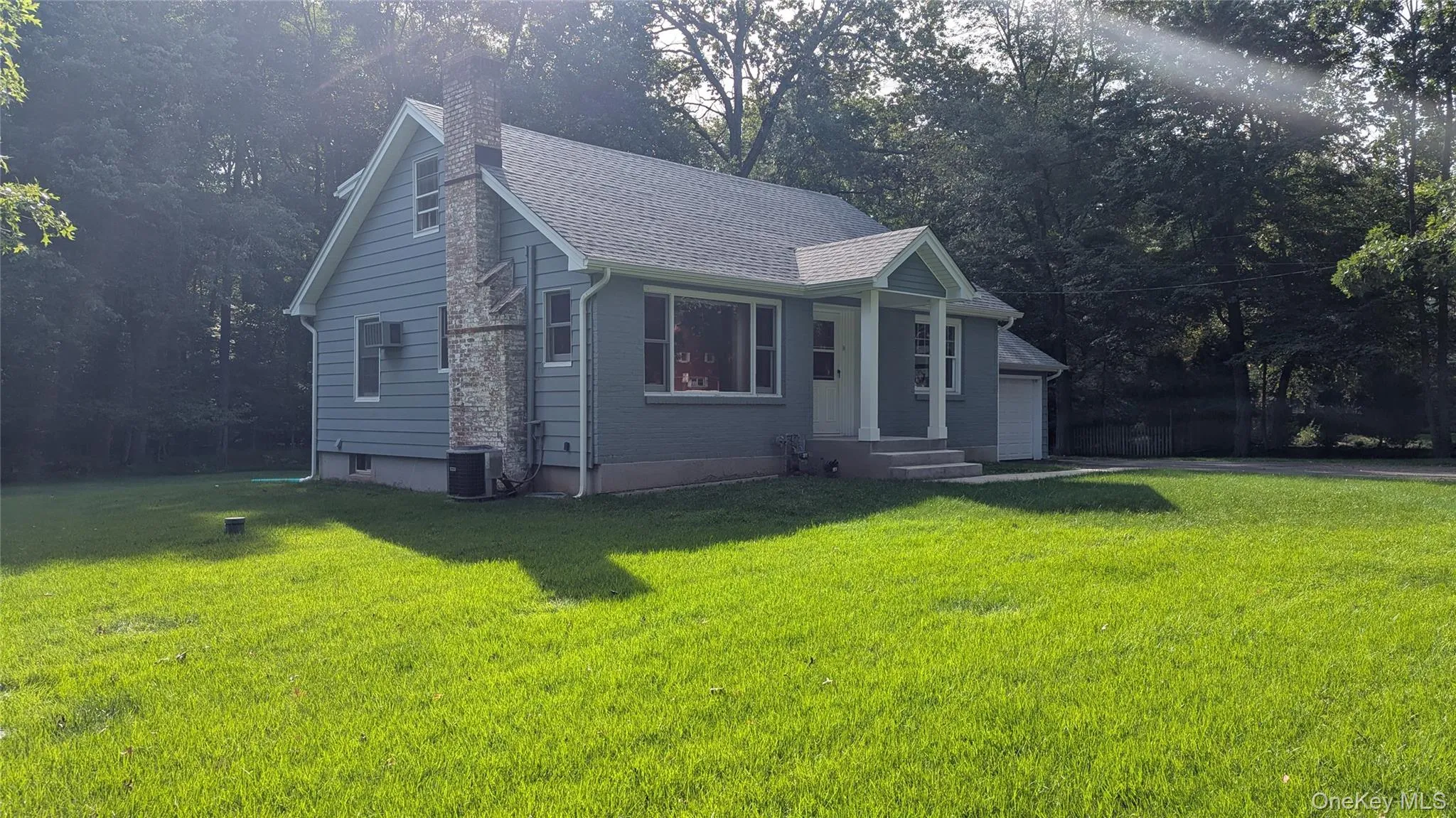 Siding exterior, covered entry, attached garage, and mature trees Siding exterior, covered entry, attached garage, and mature trees