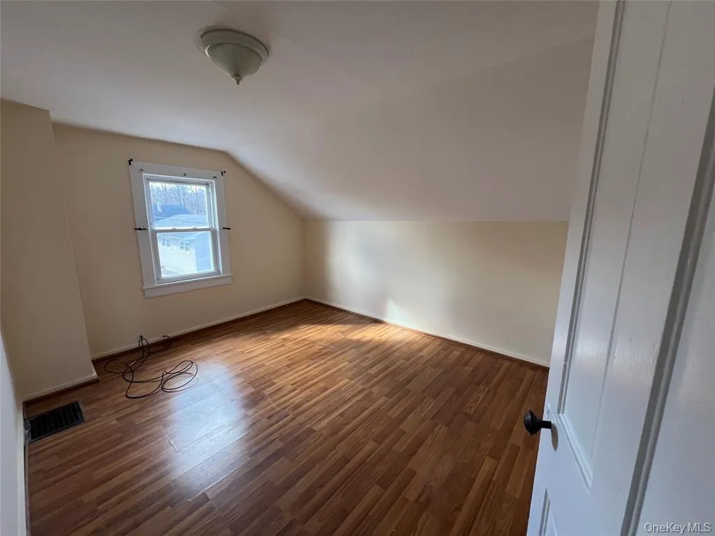 Wood-finish flooring with a window and white trim Wood-finish flooring with a window and white trim