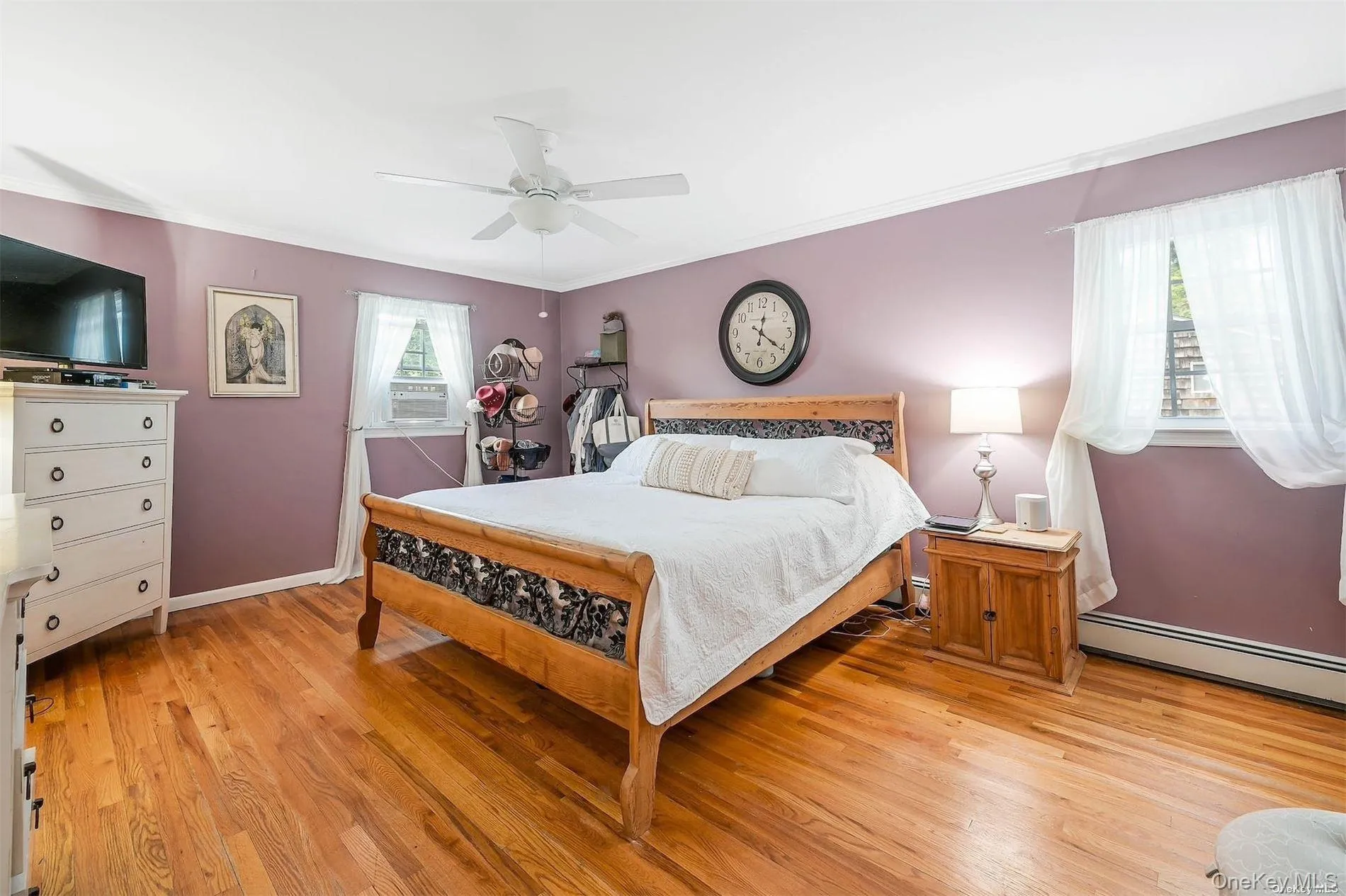 Wood-finish flooring throughout, ceiling fan with integrated lighting, and multiple windows providing natural illumination Wood-finish flooring throughout, ceiling fan with integrated lighting, and multiple windows providing natural illumination