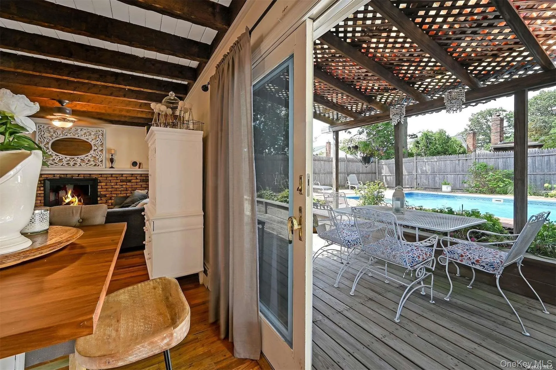 Deck with wood lattice pergola, outdoor dining area, and in-ground swimming pool Deck with wood lattice pergola, outdoor dining area, and in-ground swimming pool