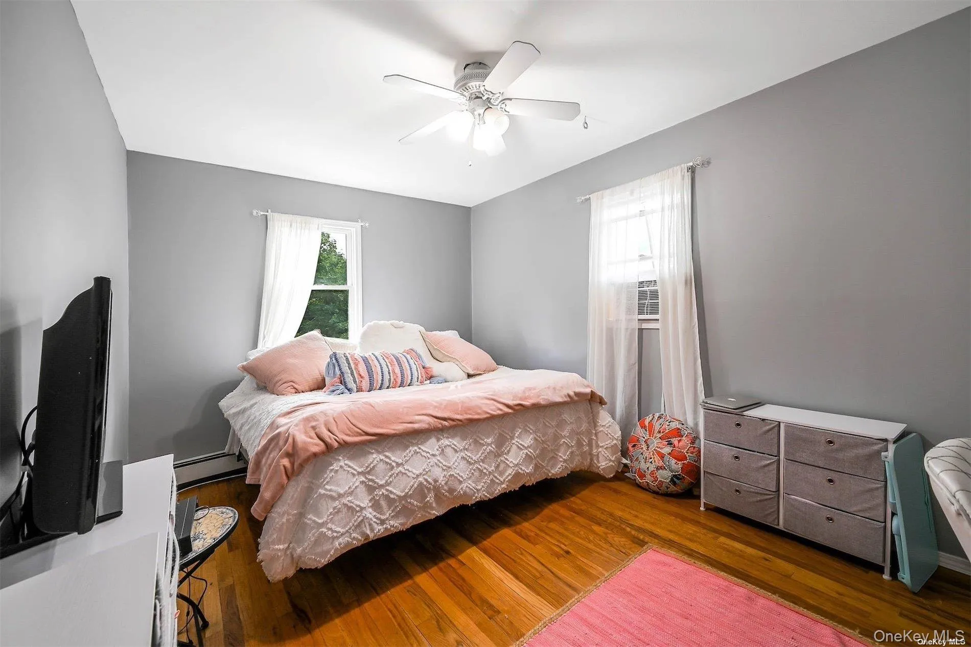Hardwood flooring, painted walls, ceiling fan with integrated lighting, and window treatments Hardwood flooring, painted walls, ceiling fan with integrated lighting, and window treatments