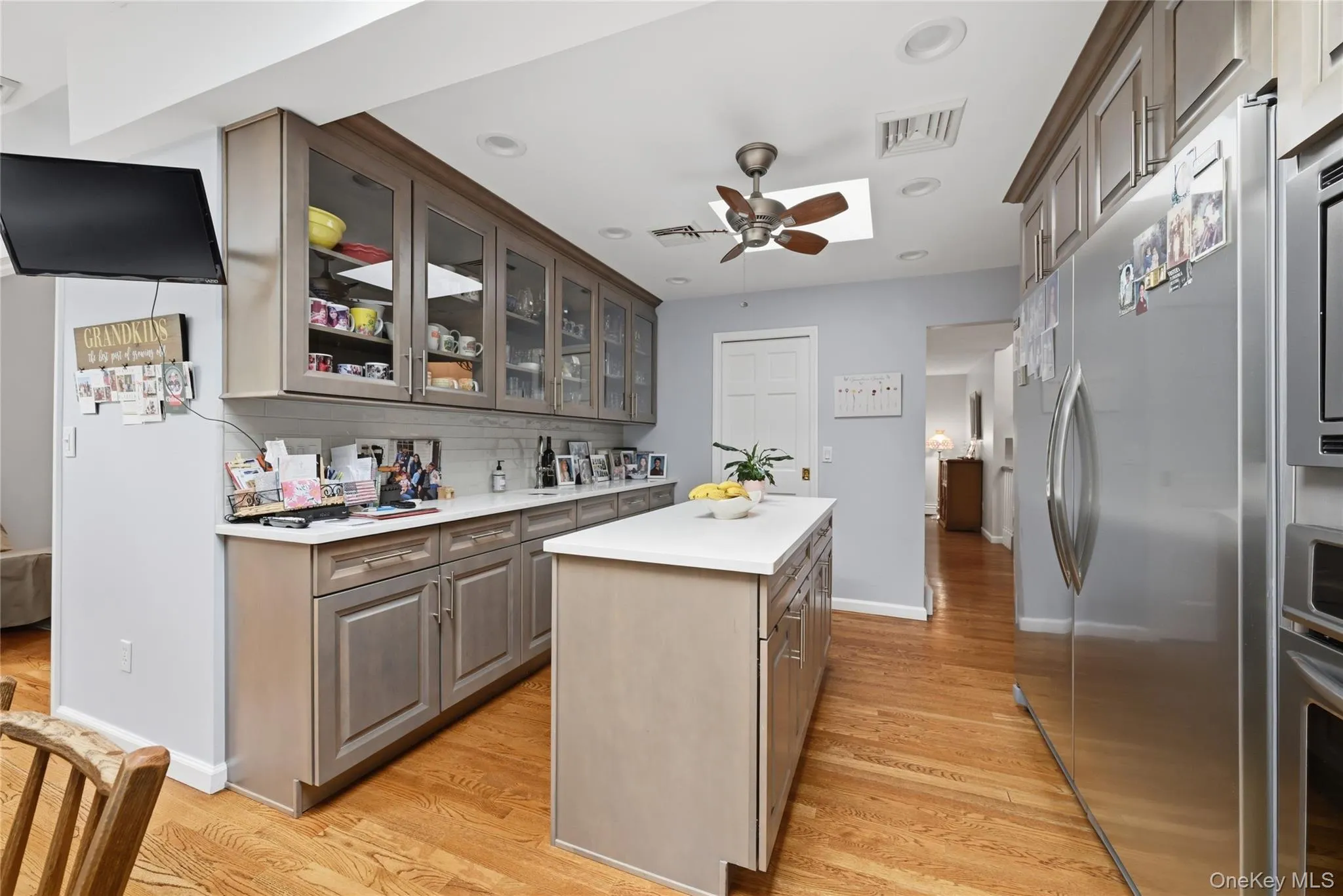 Spacious kitchen featuring wood-finish flooring, an island, recessed lighting, and a ceiling fan Spacious kitchen featuring wood-finish flooring, an island, recessed lighting, and a ceiling fan