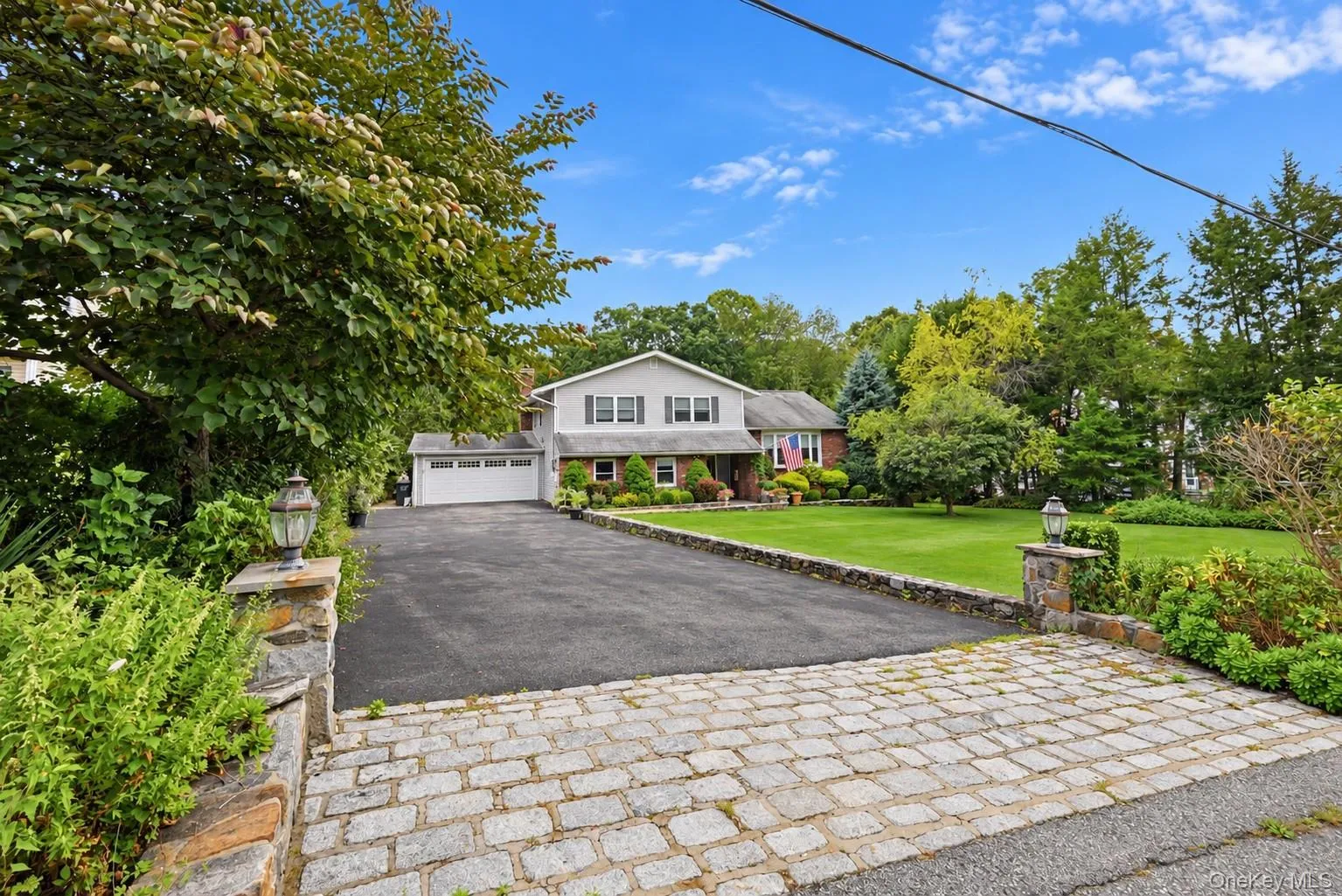 Expansive paved driveway with cobblestone entrance Expansive paved driveway with cobblestone entrance
