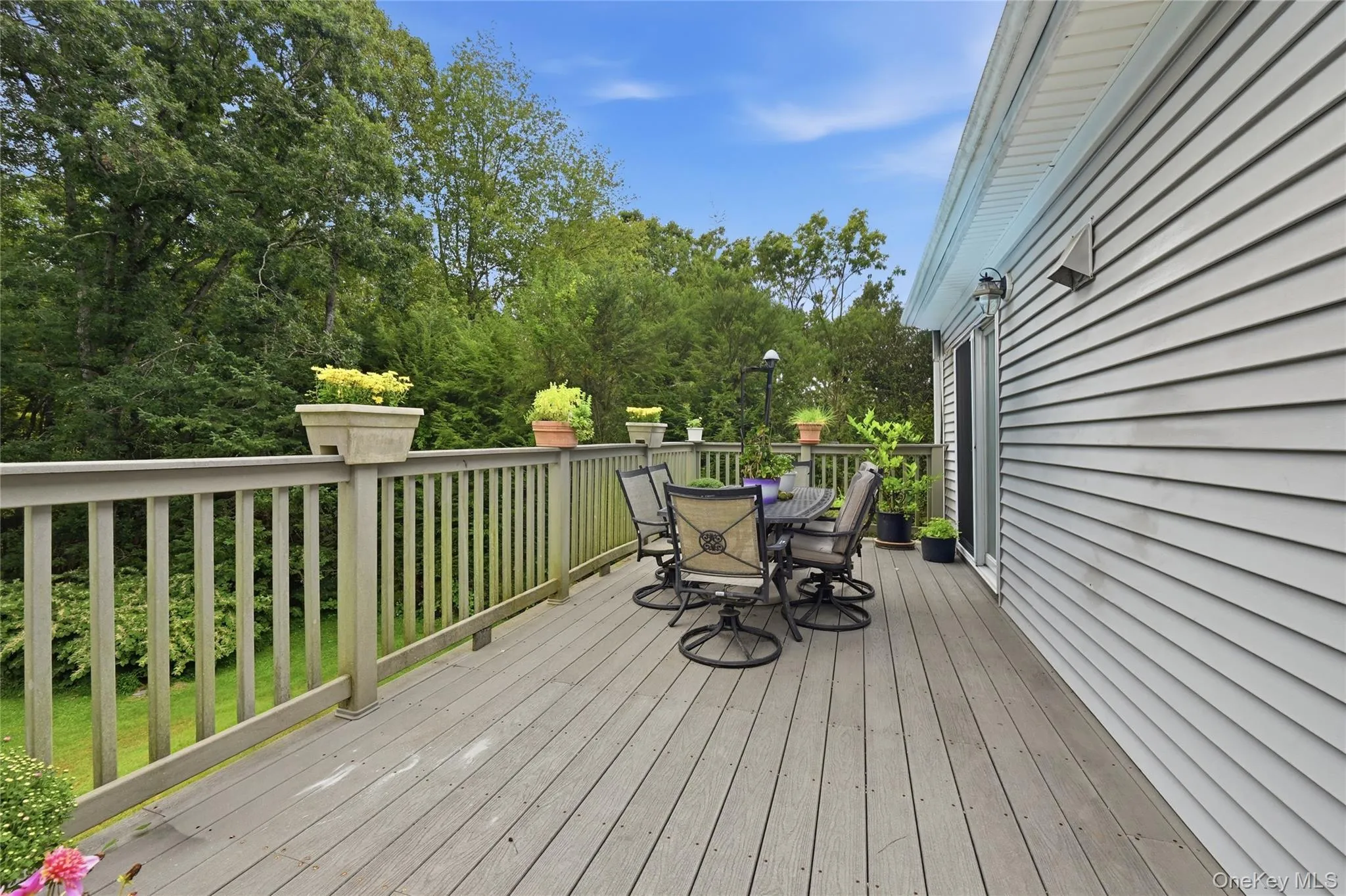 Expansive outdoor deck with a composite- finish surface and a sturdy railing system Expansive outdoor deck with a composite- finish surface and a sturdy railing system