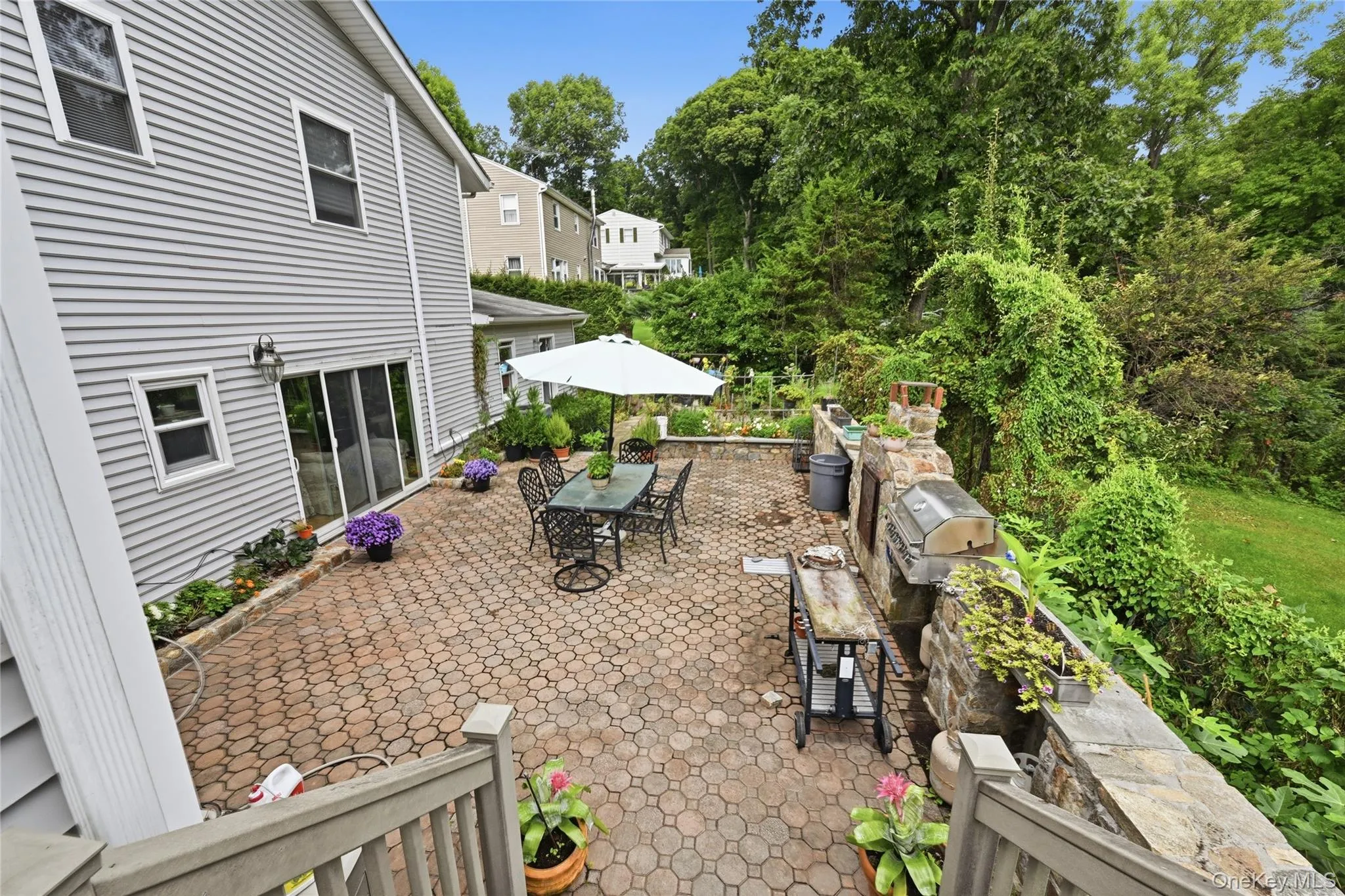 Paver patio with a stone outdoor kitchen featuring a built-in grill and pizza oven Paver patio with a stone outdoor kitchen featuring a built-in grill and pizza oven