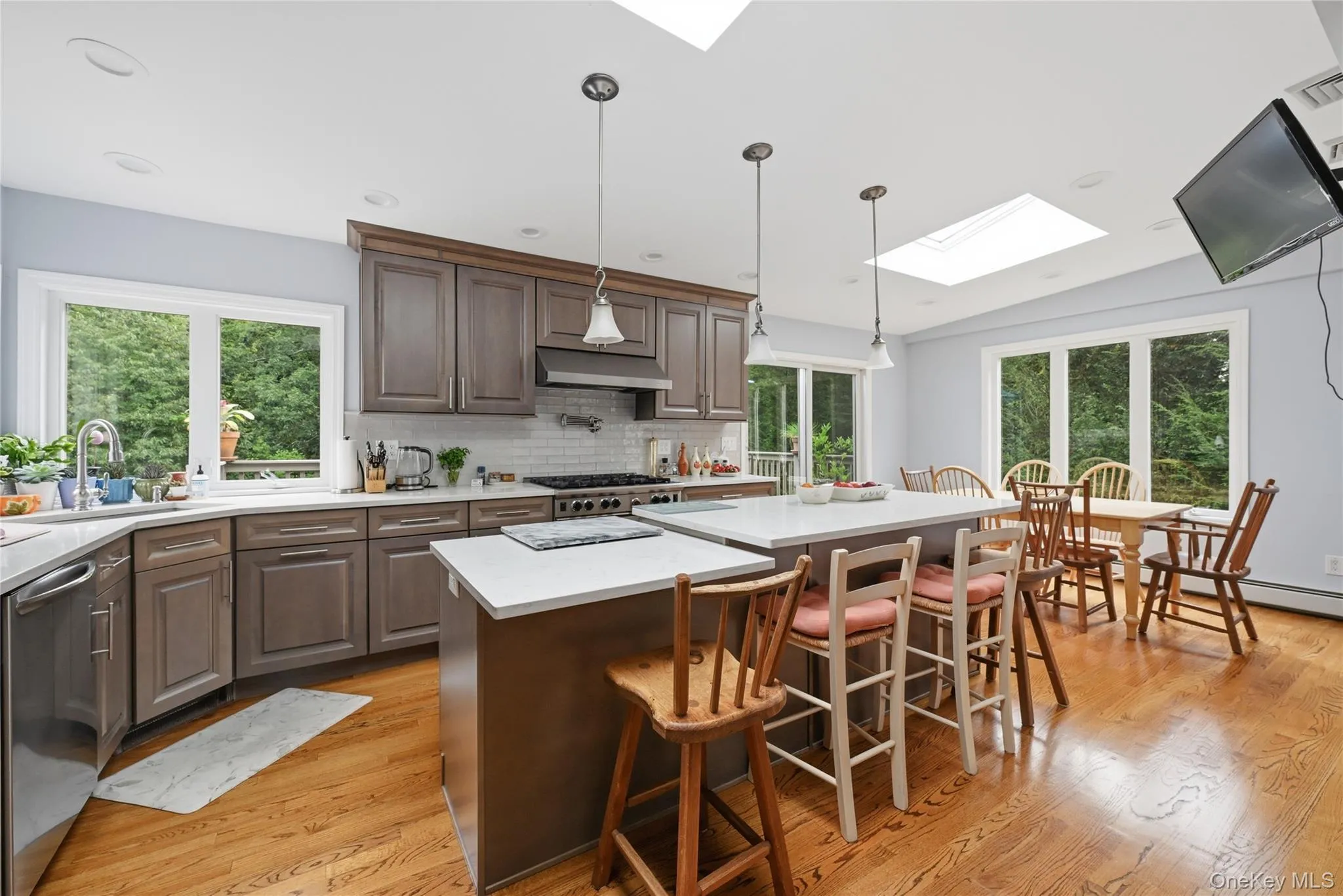 Kitchen with wood-finish flooring, recessed lighting, and skylights Kitchen with wood-finish flooring, recessed lighting, and skylights