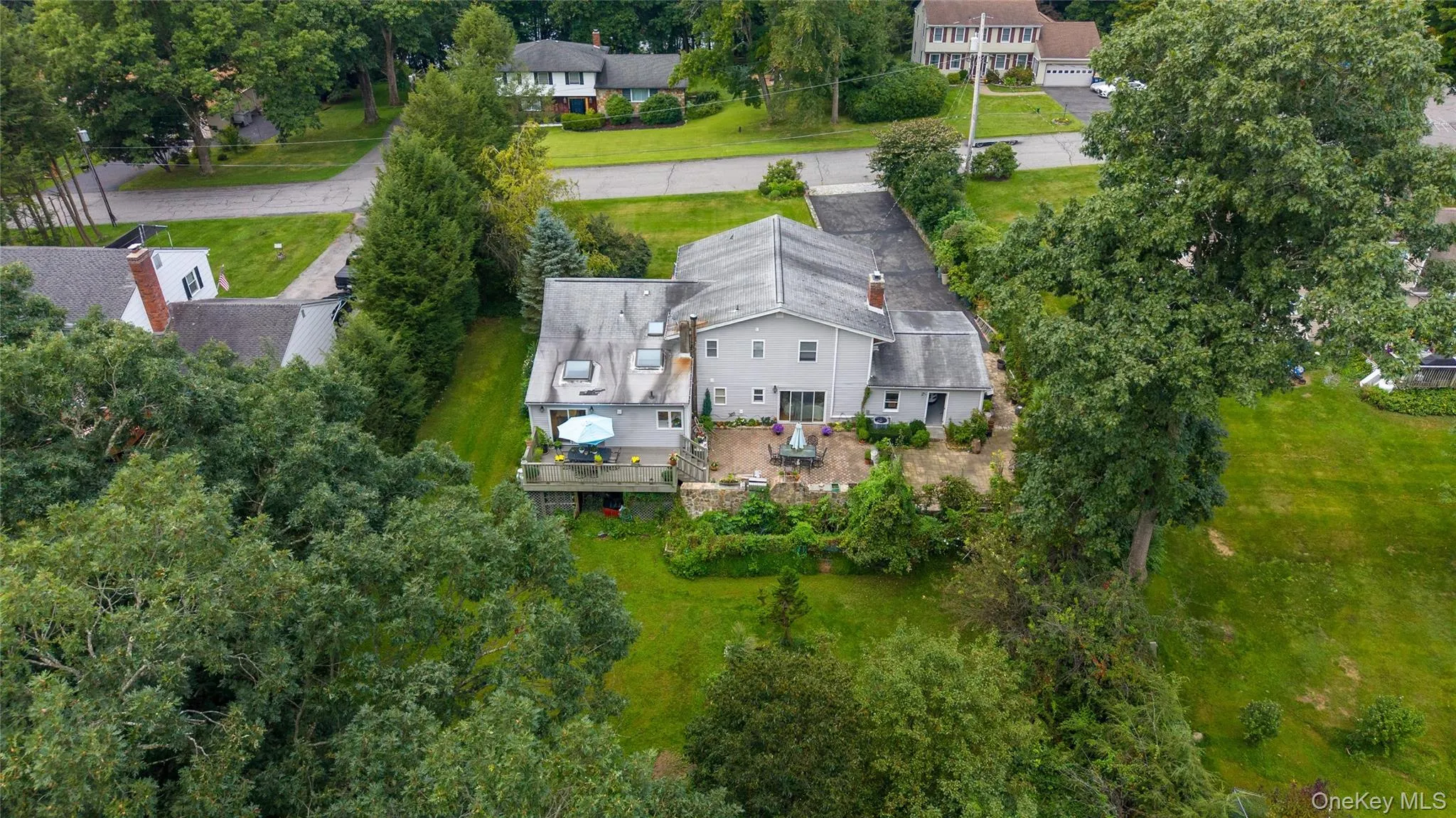 Expansive rear patio with direct outdoor access and mature landscaping Expansive rear patio with direct outdoor access and mature landscaping