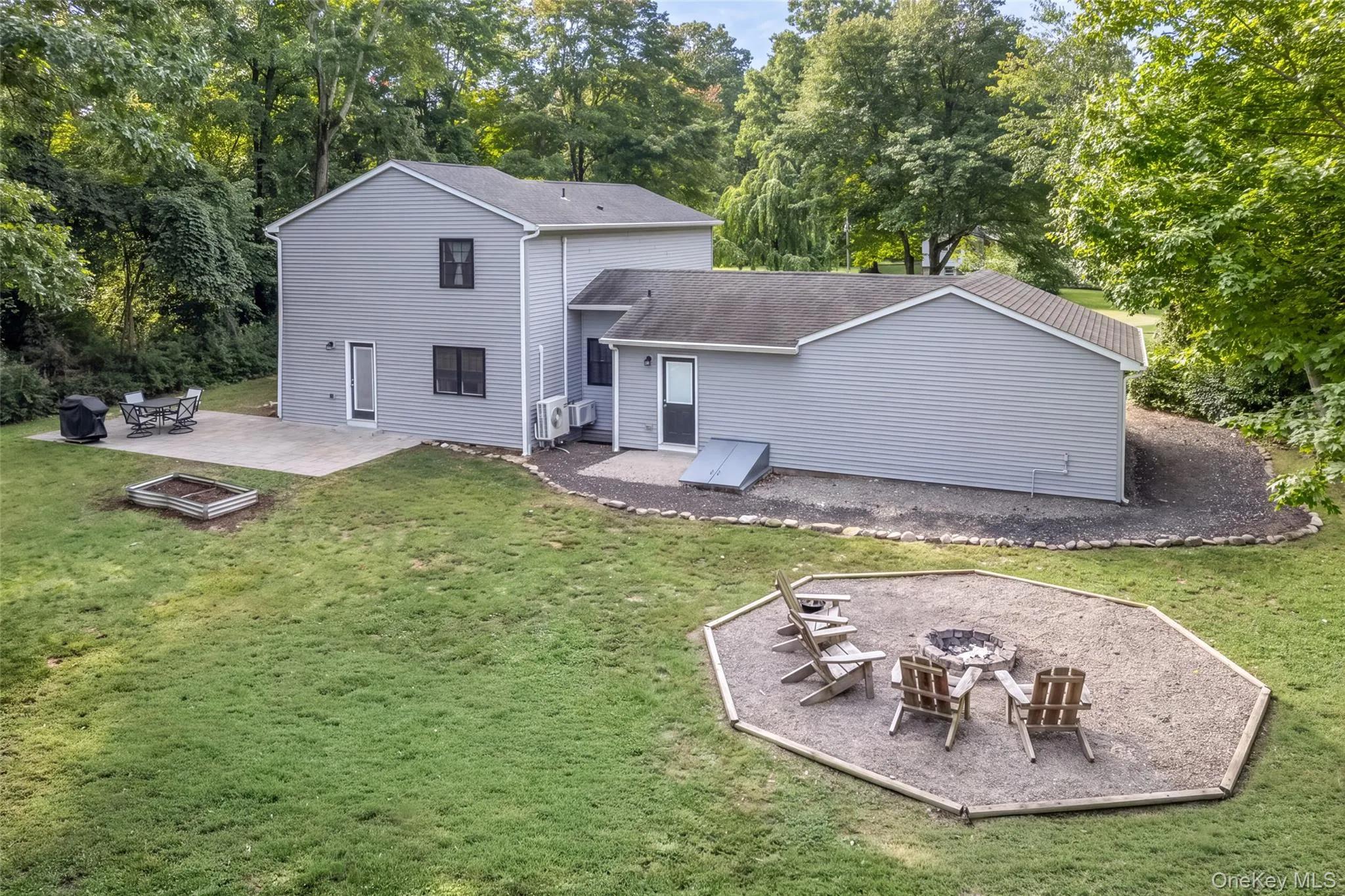 Expansive green lawn featuring a dedicated fire pit area and patio Expansive green lawn featuring a dedicated fire pit area and patio