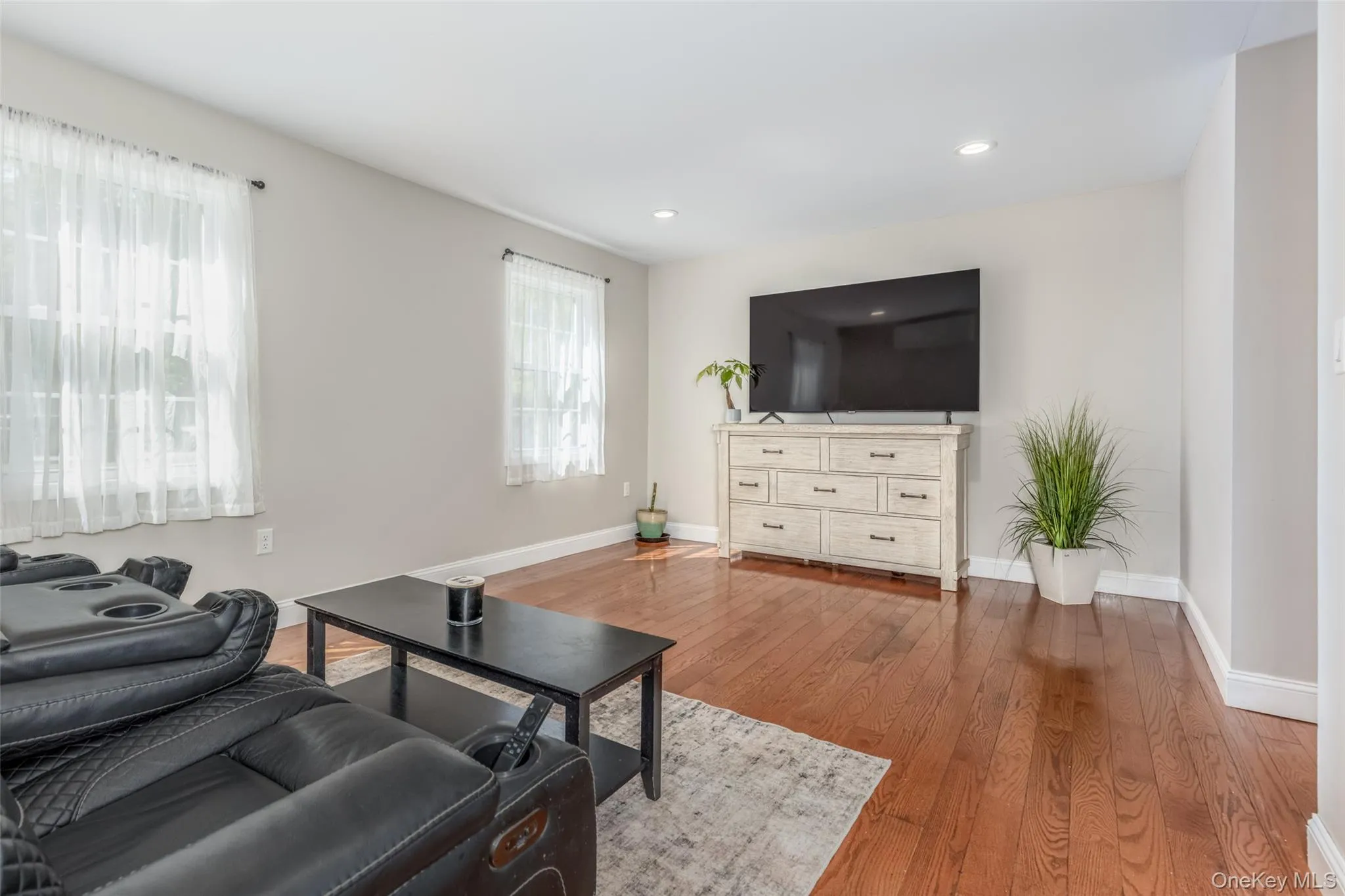 Hardwood flooring, recessed lighting, and light gray wall finishes Hardwood flooring, recessed lighting, and light gray wall finishes