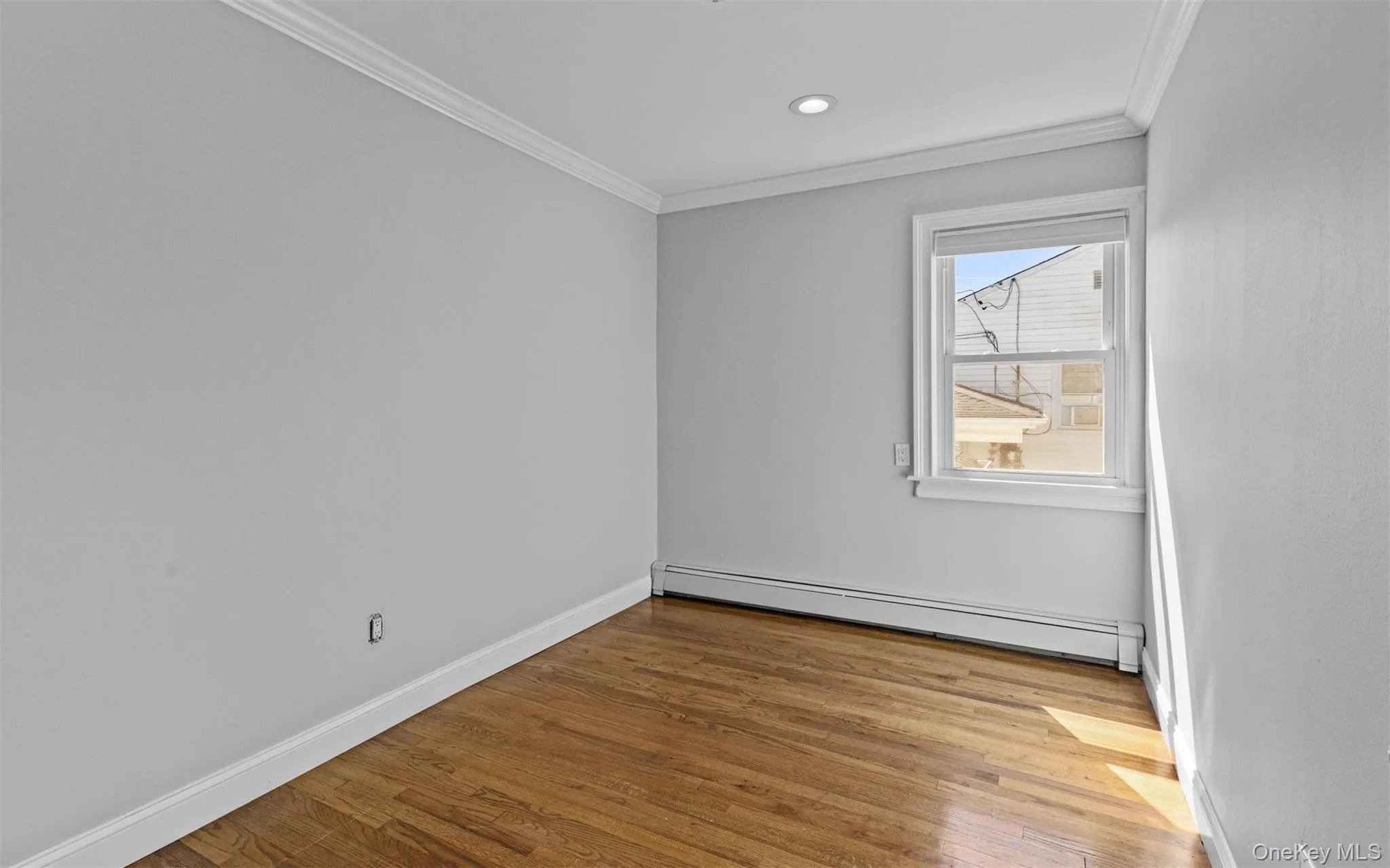 Wood-finish flooring, single window, recessed lighting, white baseboards, and crown molding Wood-finish flooring, single window, recessed lighting, white baseboards, and crown molding