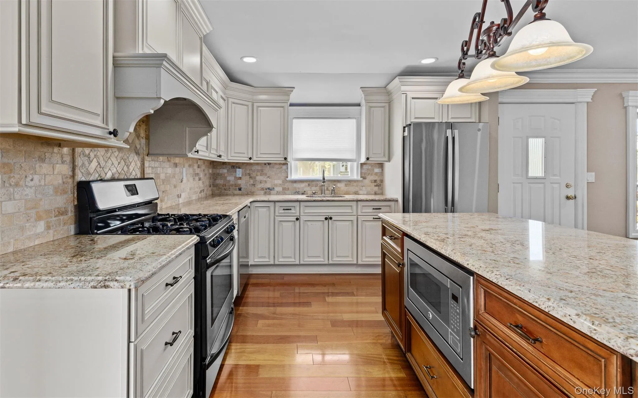 Hardwood flooring, light-toned cabinetry, and stone countertops Hardwood flooring, light-toned cabinetry, and stone countertops