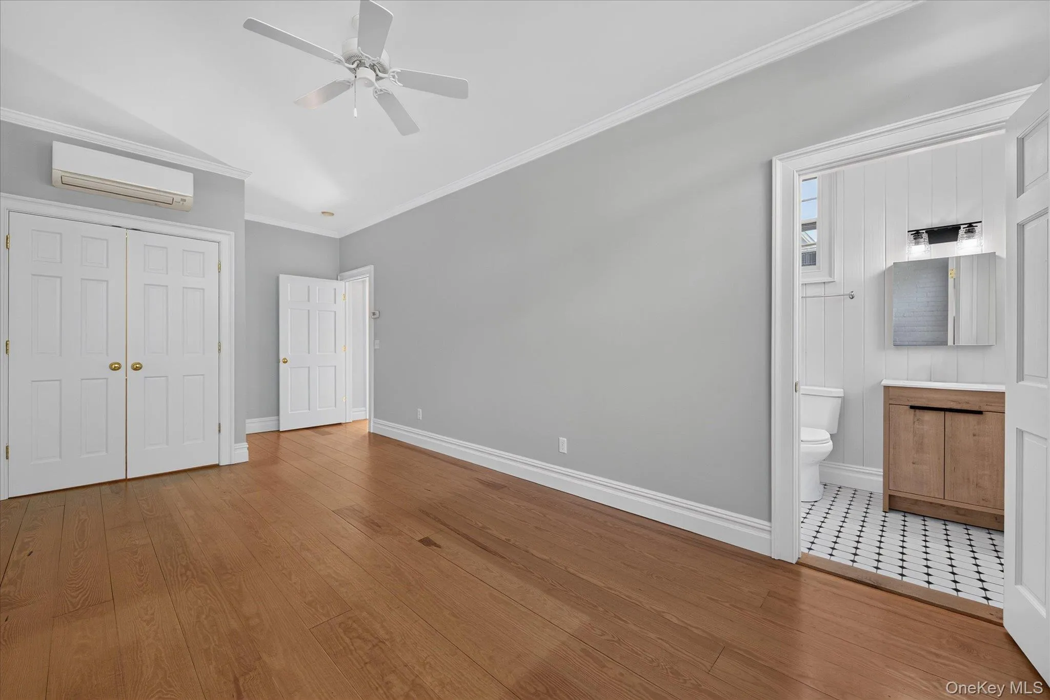 Wood-finish flooring, ceiling fan, white paneled doors, and crown molding Wood-finish flooring, ceiling fan, white paneled doors, and crown molding