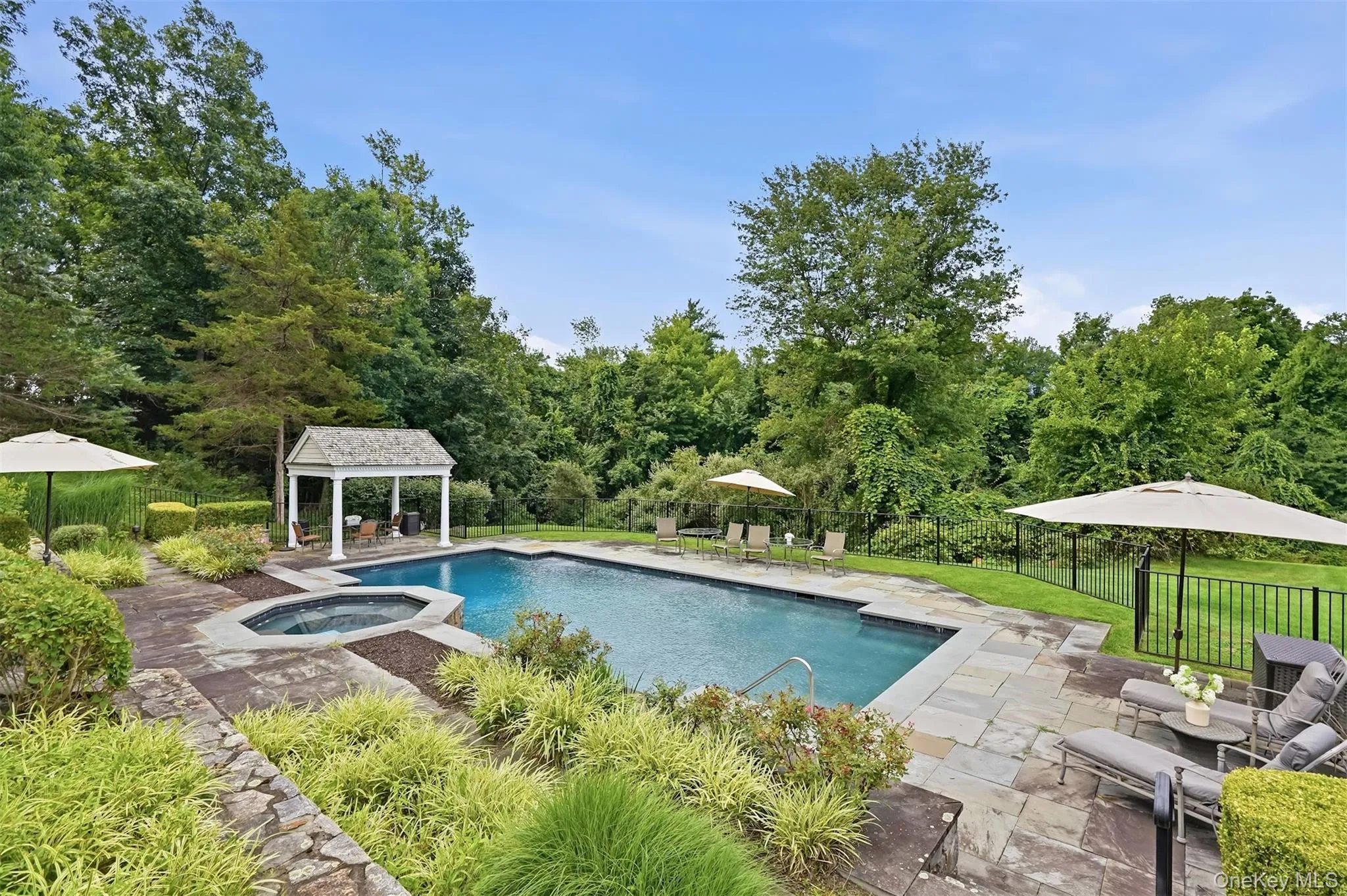 Inground heated gunite pool and spa with waterfall edge. Inground heated gunite pool and spa with waterfall edge.