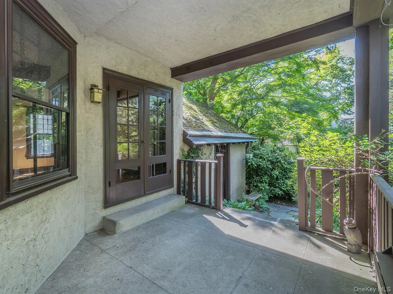 Covered patio/porch of the dining room with steps down to the pond Covered patio/porch of the dining room with steps down to the pond