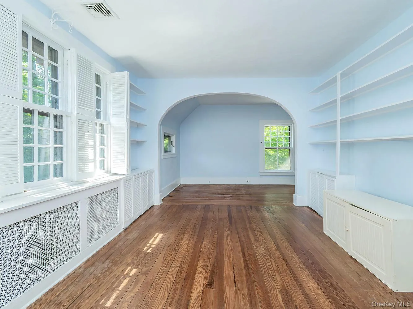 Primary bedroom with built in shelving and original archways Primary bedroom with built in shelving and original archways