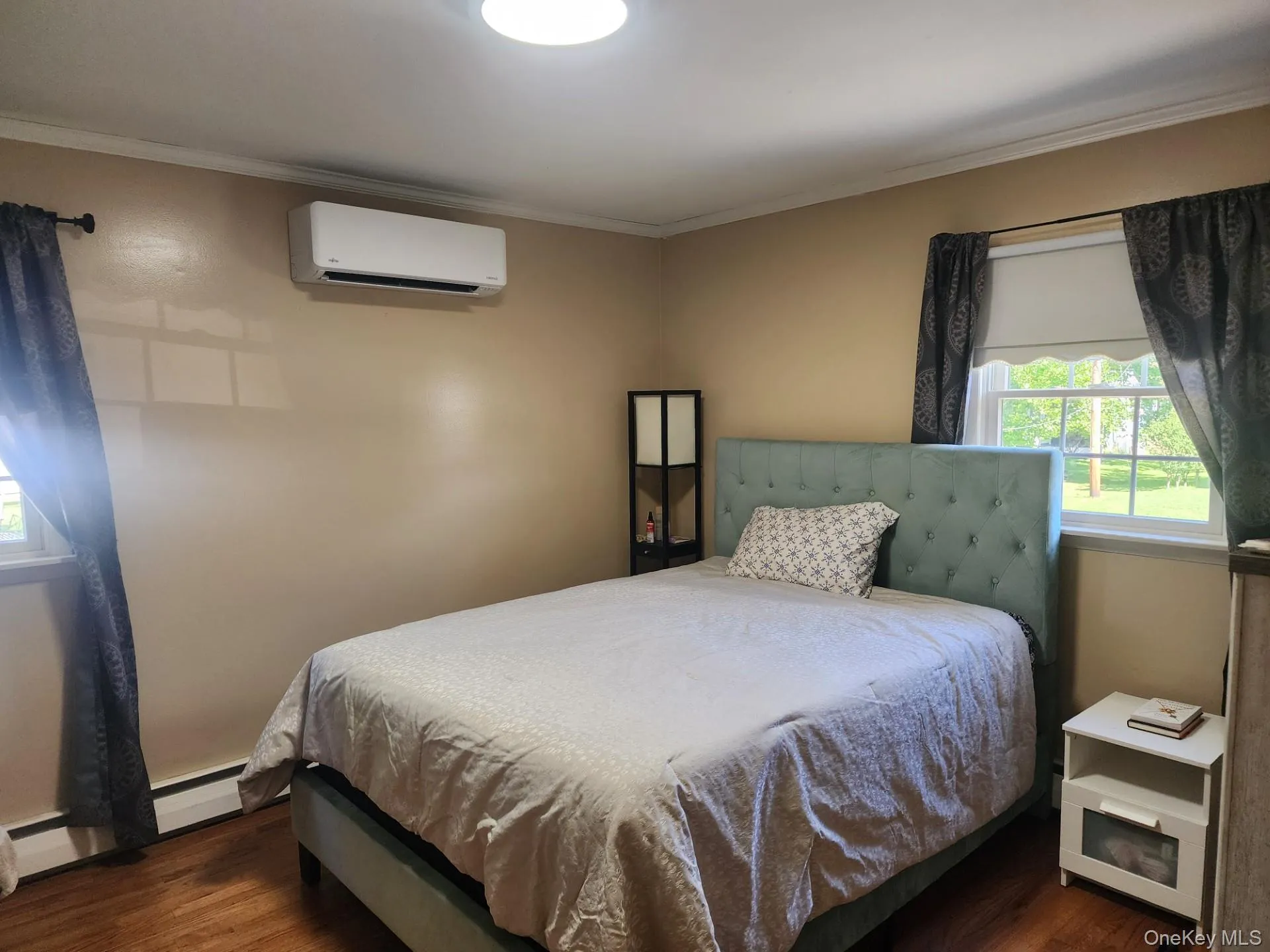 Primary Bedroom with 2 windows, hardwood floors and mini-split Primary Bedroom with 2 windows, hardwood floors and mini-split