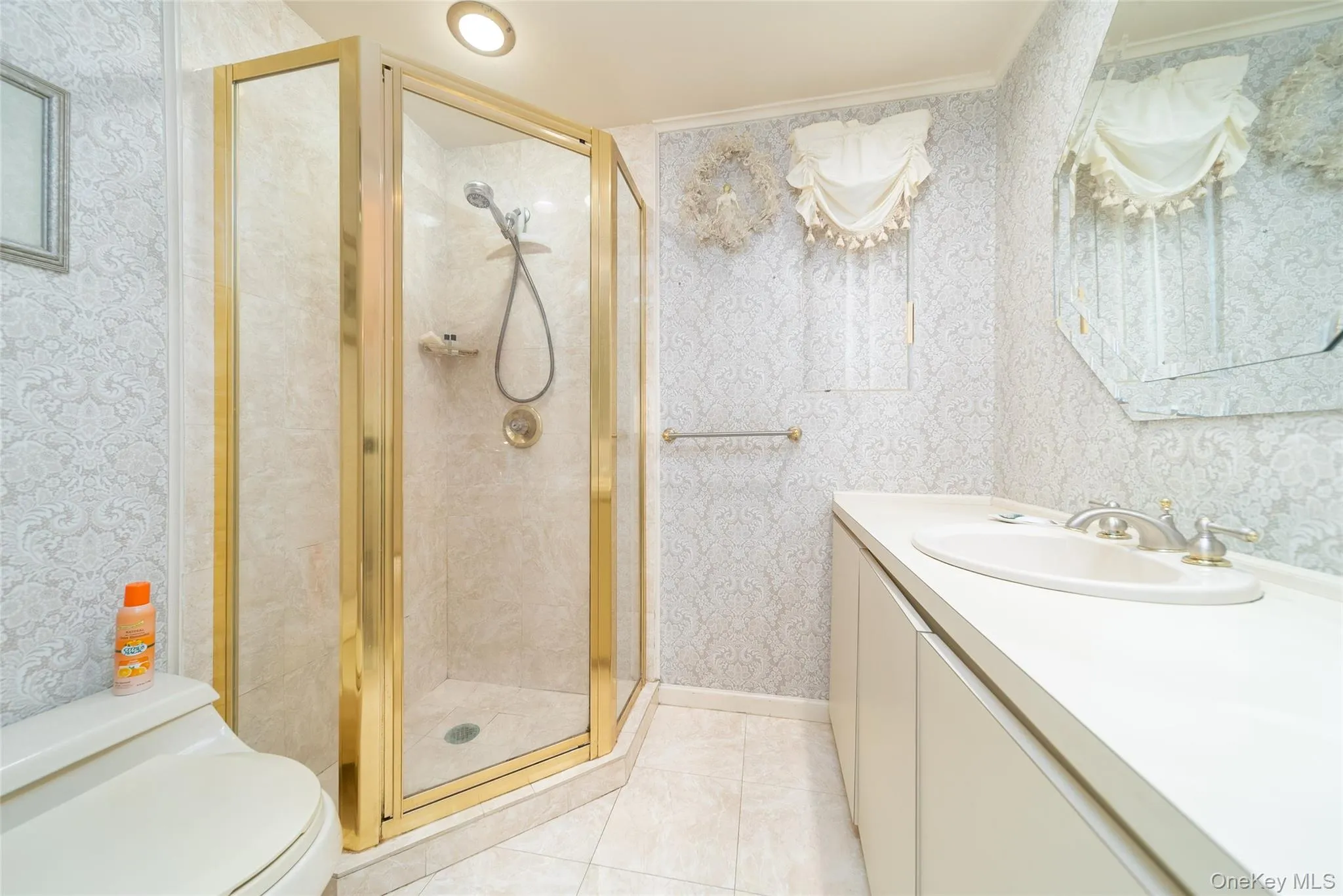 Full bathroom with wallpapered walls, vanity, and a stall shower Full bathroom with wallpapered walls, vanity, and a stall shower