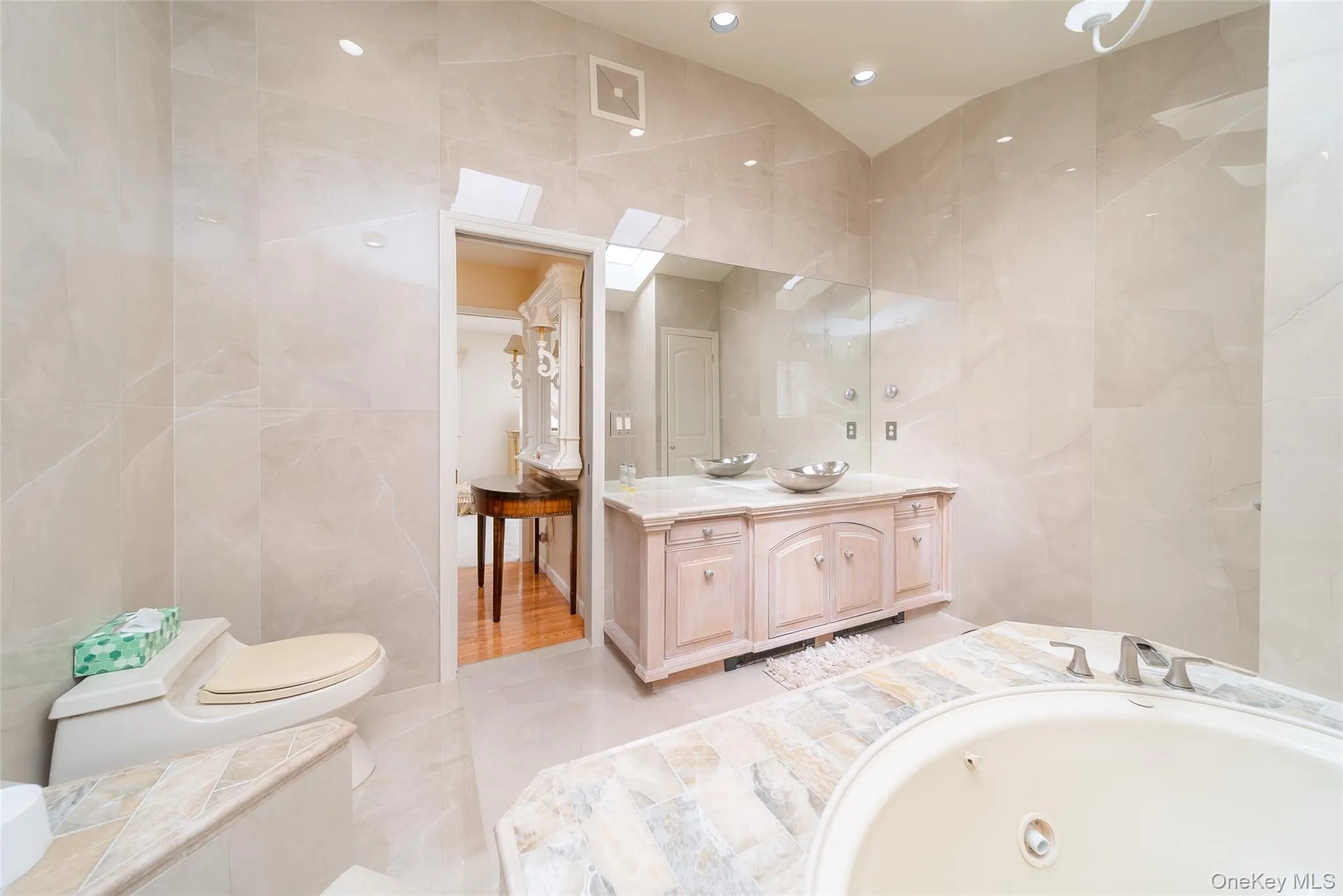Full bath with tile walls, vanity, a garden tub, and recessed lighting Full bath with tile walls, vanity, a garden tub, and recessed lighting
