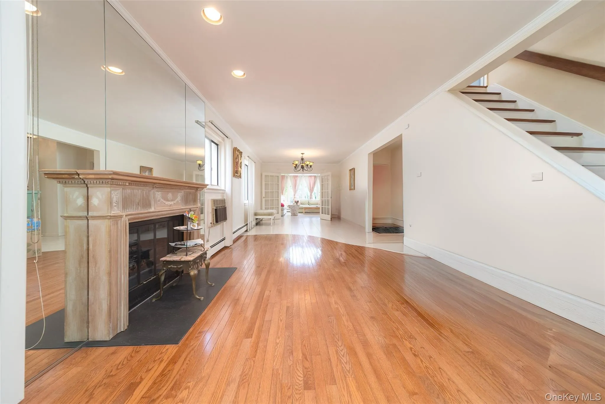 Living area with a fireplace, hardwood / wood-style flooring, a chandelier, stairway, and recessed lighting Living area with a fireplace, hardwood / wood-style flooring, a chandelier, stairway, and recessed lighting