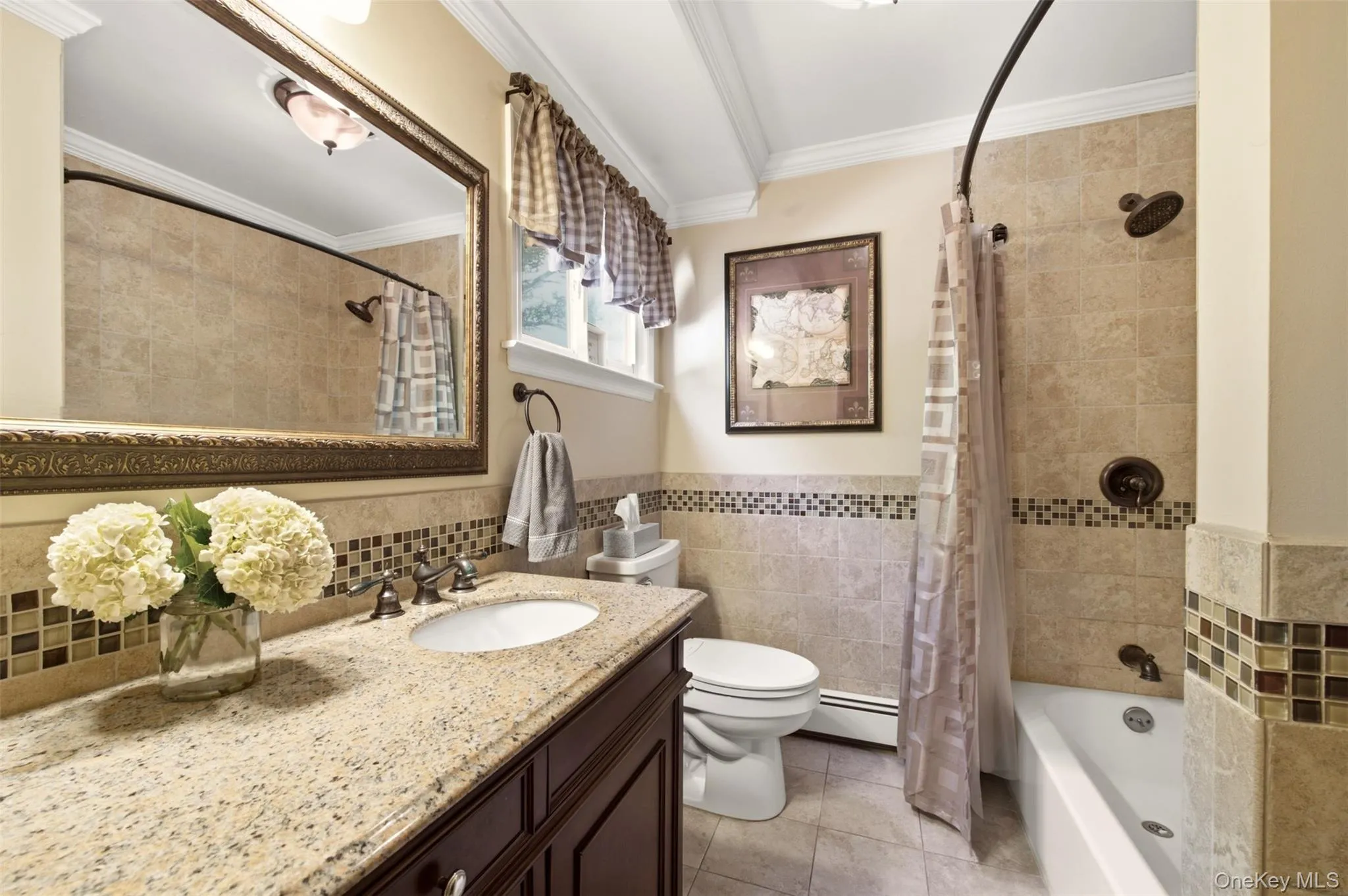 Granite vanity countertop with an undermount sink, dark wood-finish cabinetry, tile flooring, and a tiled shower/tub combination with mosaic accent banding Granite vanity countertop with an undermount sink, dark wood-finish cabinetry, tile flooring, and a tiled shower/tub combination with mosaic accent banding