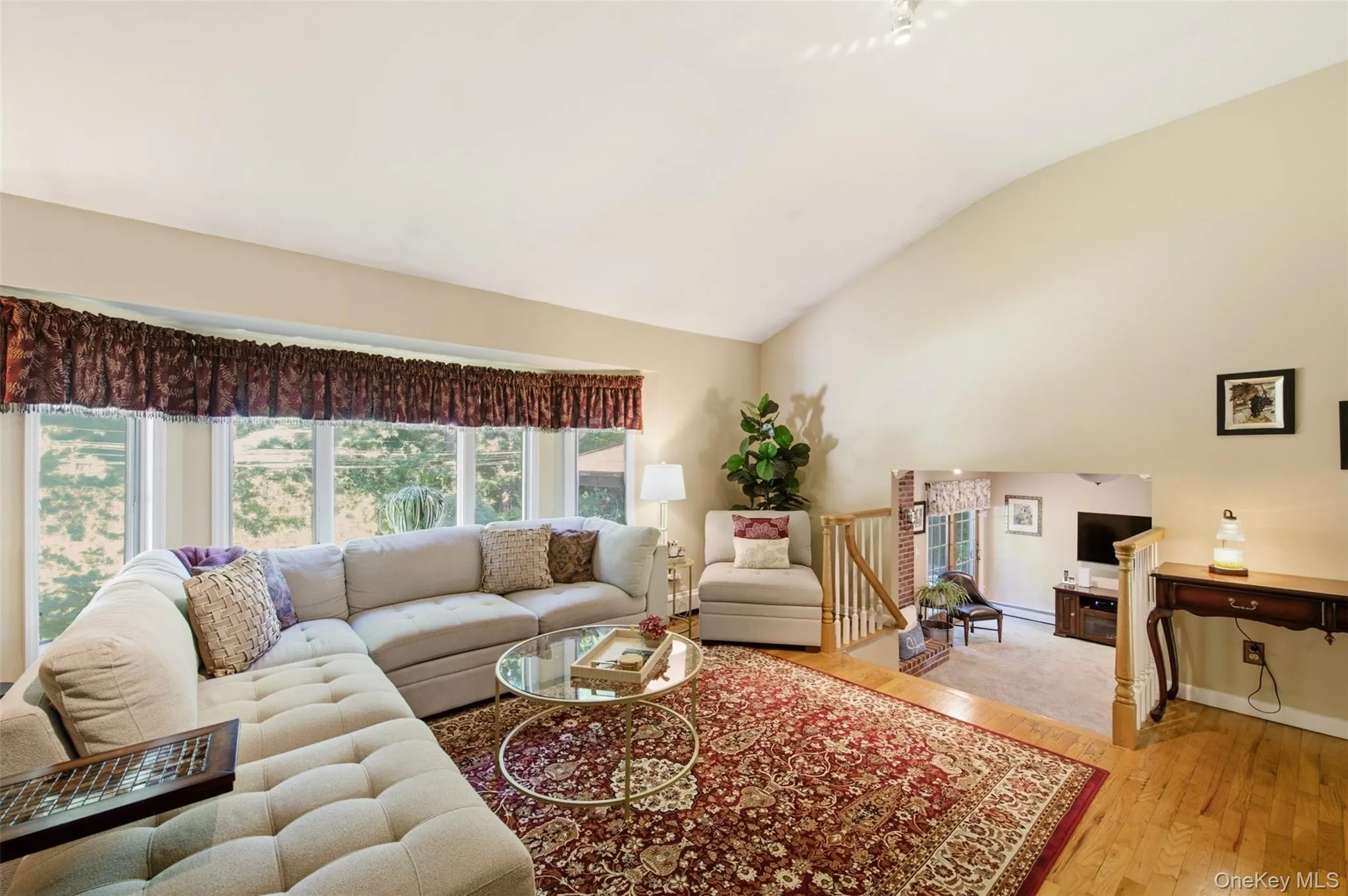 Vaulted ceiling, hardwood flooring, and a bay window Vaulted ceiling, hardwood flooring, and a bay window
