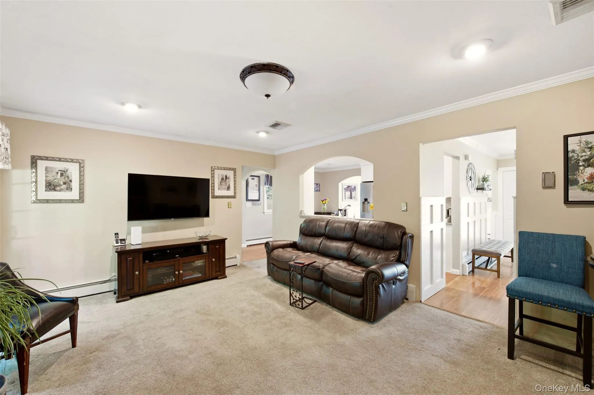 Neutral wall tones, recessed lighting, crown molding, and an arched doorway Neutral wall tones, recessed lighting, crown molding, and an arched doorway