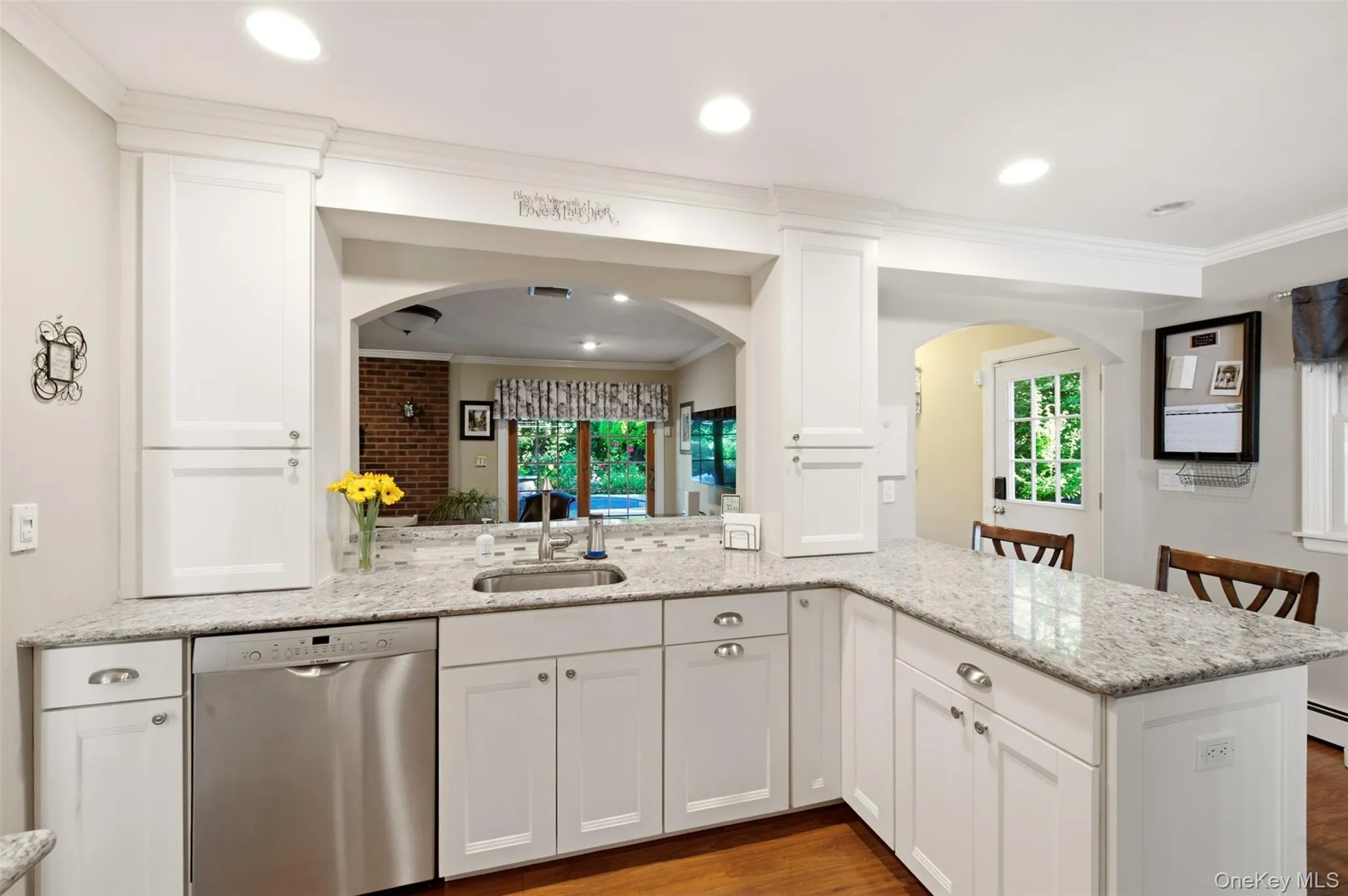 Kitchen featuring white cabinetry, light-toned countertops, a stainless steel dishwasher, and recessed lighting Kitchen featuring white cabinetry, light-toned countertops, a stainless steel dishwasher, and recessed lighting