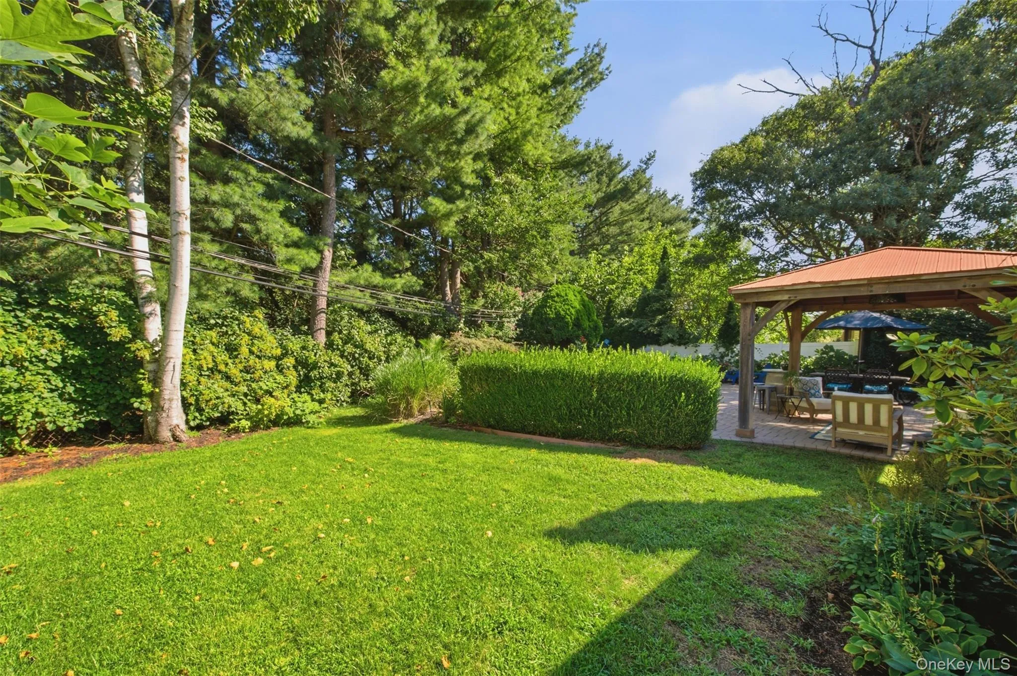 Expansive lawn area, mature trees, manicured hedges, and a covered patio with a gazebo Expansive lawn area, mature trees, manicured hedges, and a covered patio with a gazebo