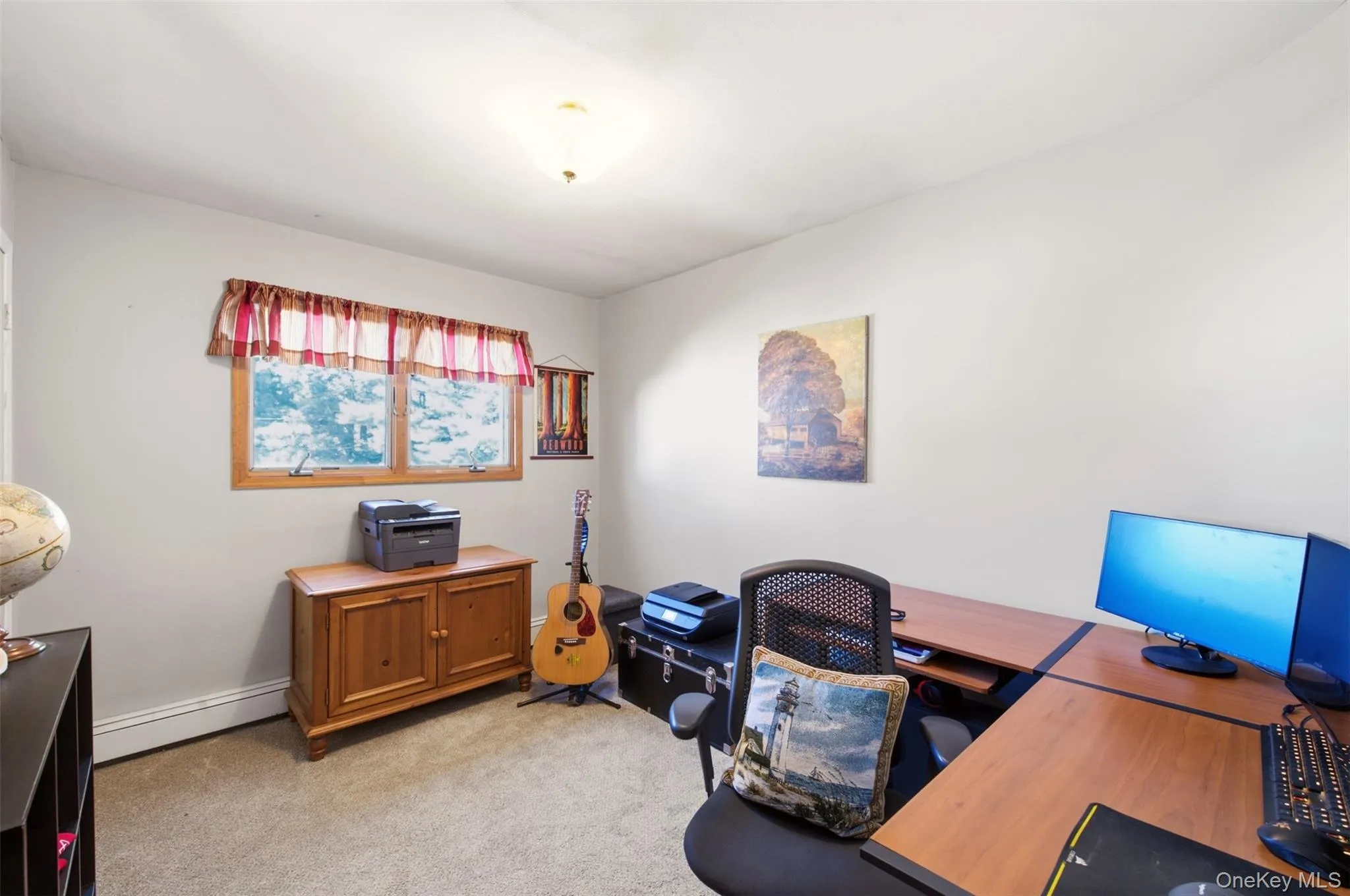 Carpeted room featuring a double-hung window with wood trim, ceiling-mounted light fixture, and light-toned walls Carpeted room featuring a double-hung window with wood trim, ceiling-mounted light fixture, and light-toned walls