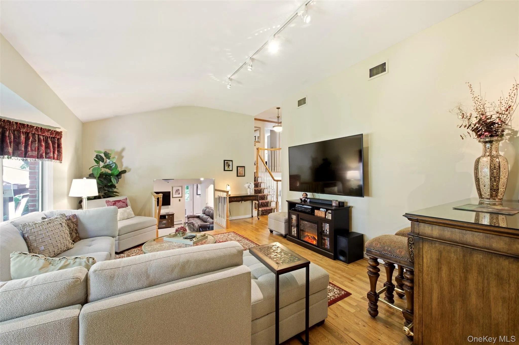 Vaulted ceiling, hardwood flooring, and a bay window Vaulted ceiling, hardwood flooring, and a bay window
