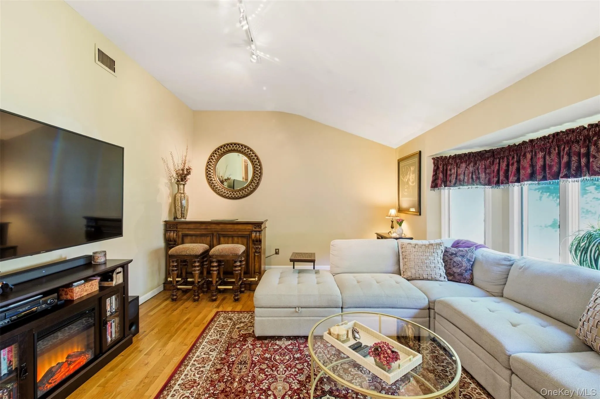 Vaulted ceiling, hardwood flooring, and a bay window Vaulted ceiling, hardwood flooring, and a bay window