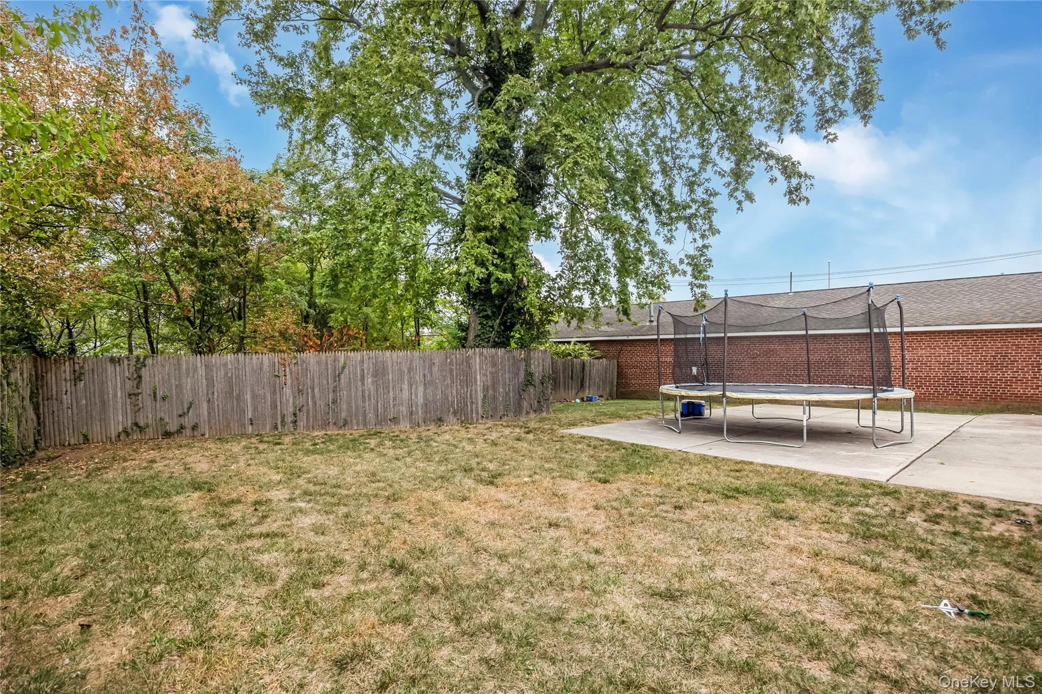 Fenced backyard featuring a trampoline Fenced backyard featuring a trampoline