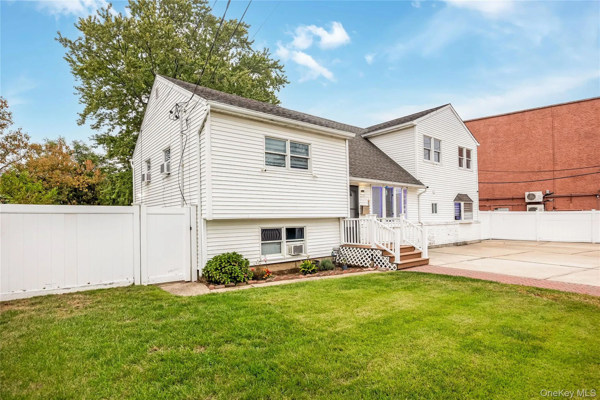 View of front of home with a fenced backyard, a shingled roof, and a patio area View of front of home with a fenced backyard, a shingled roof, and a patio area