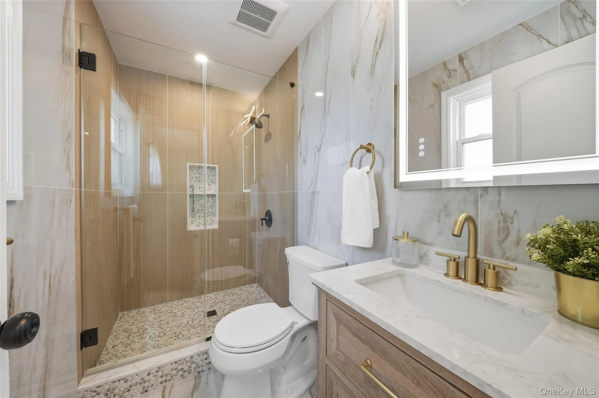 Premier Bath,Glass-enclosed shower with pebble-style flooring and integrated shelving Premier Bath,Glass-enclosed shower with pebble-style flooring and integrated shelving