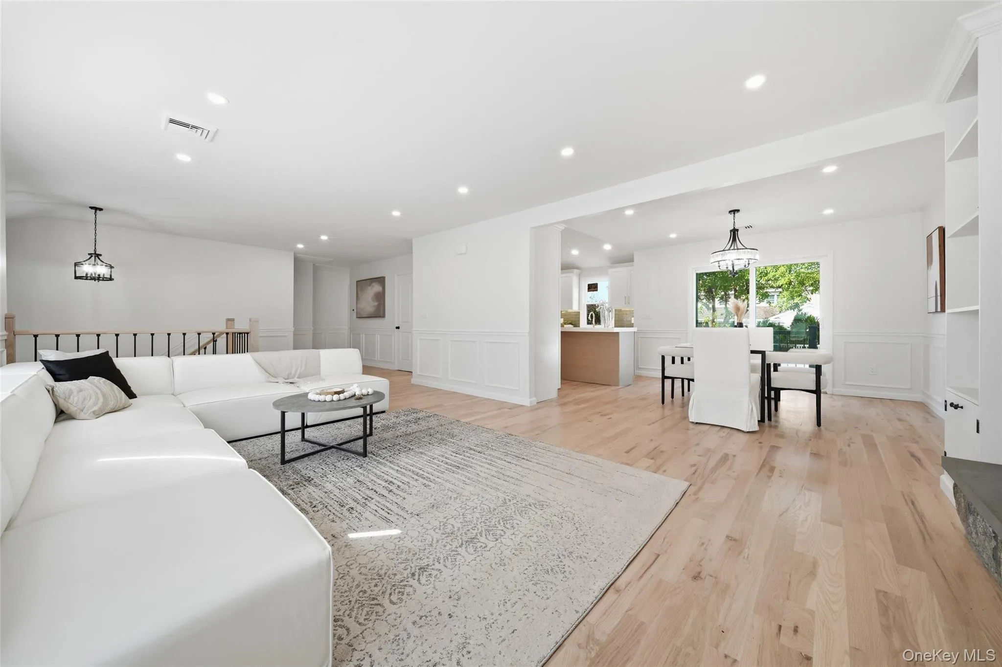 Recessed lighting throughout, wide plank wood-finish flooring, wainscoting, built-in shelving, and a decorative chandelier Recessed lighting throughout, wide plank wood-finish flooring, wainscoting, built-in shelving, and a decorative chandelier
