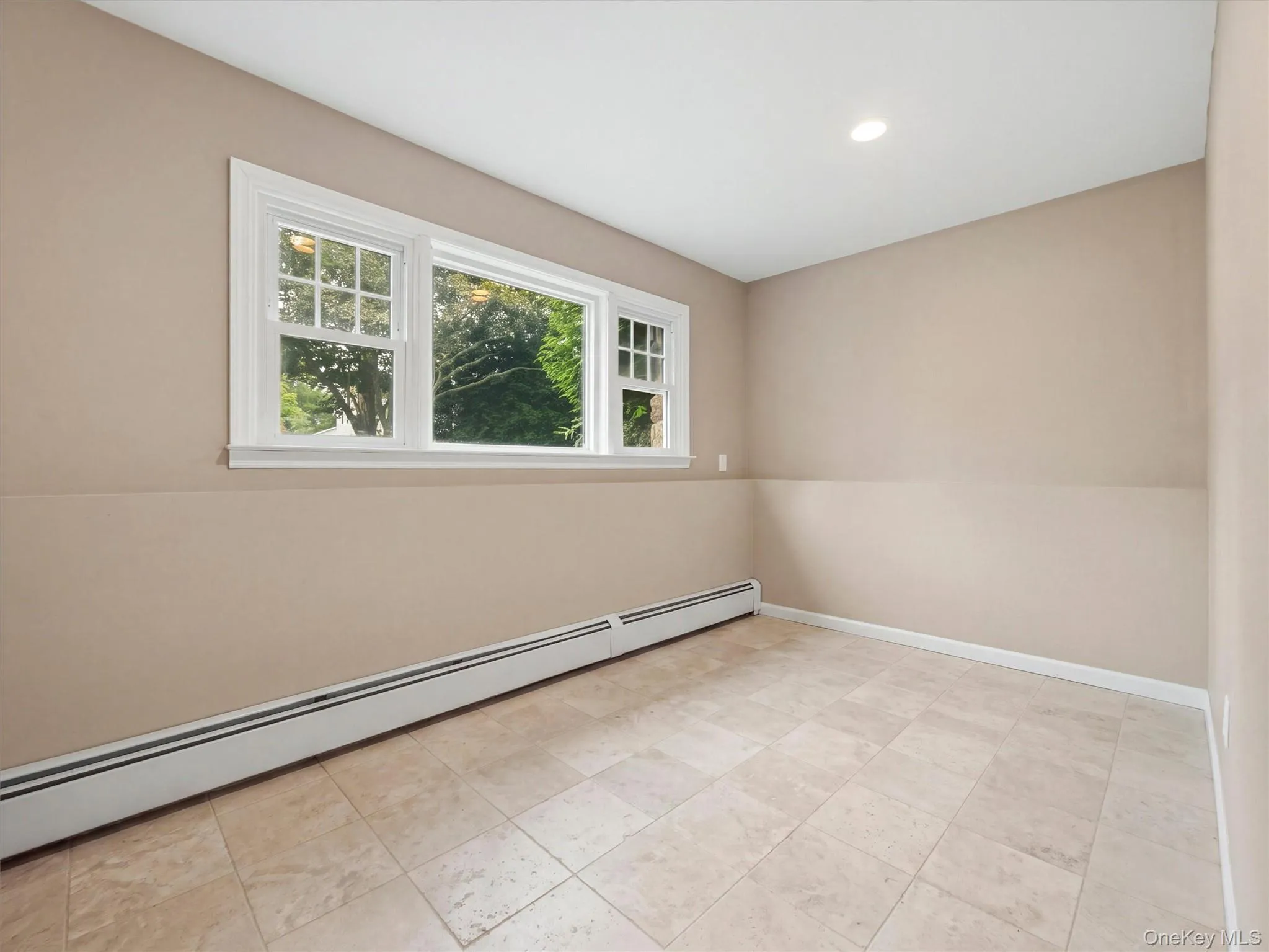 Recessed ceiling lighting, multiple windows, baseboard heating, tile flooring, and neutral wall tones Recessed ceiling lighting, multiple windows, baseboard heating, tile flooring, and neutral wall tones