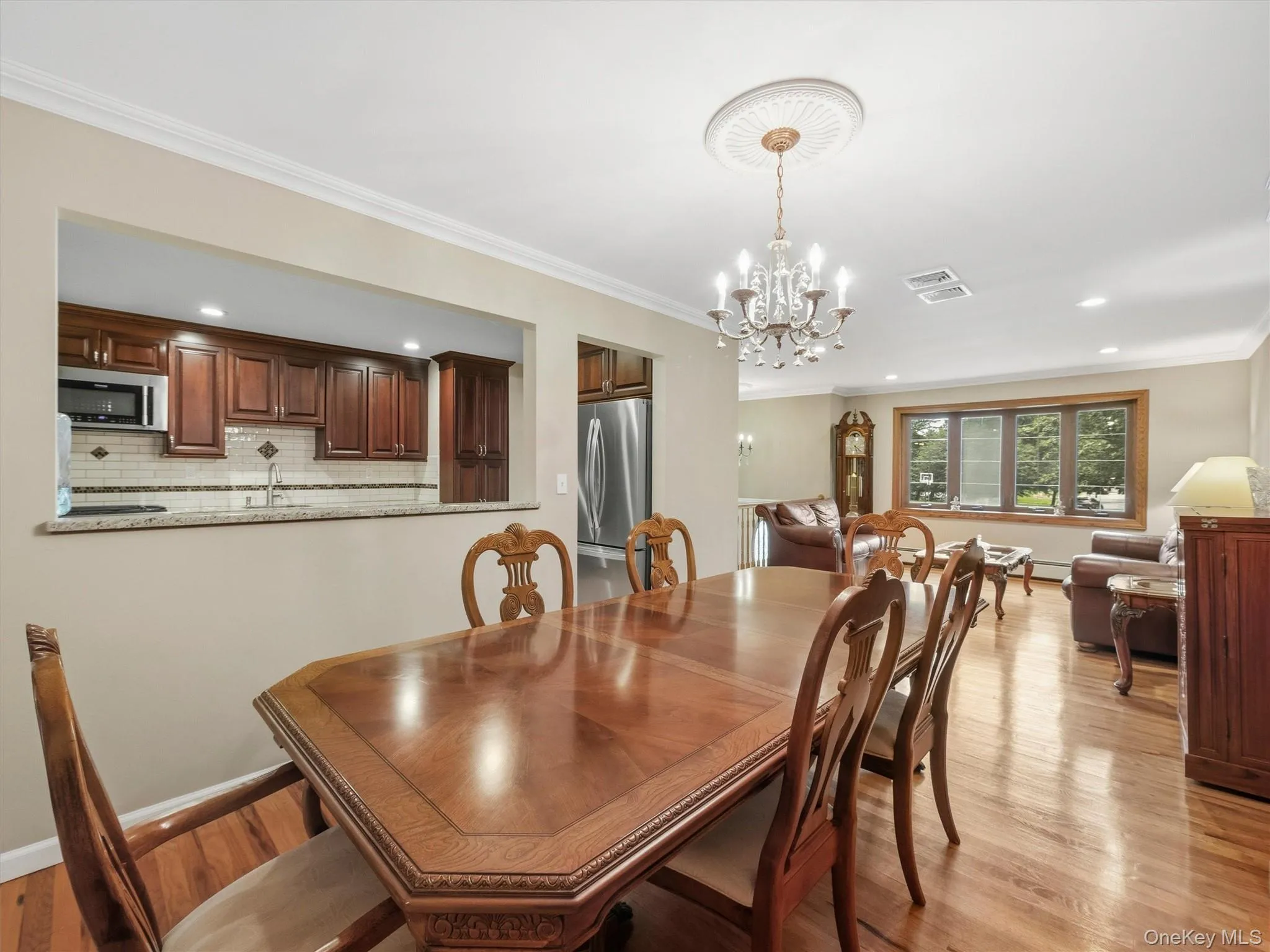 Crown molding, wood-finish flooring, and a chandelier with ceiling medallion Crown molding, wood-finish flooring, and a chandelier with ceiling medallion