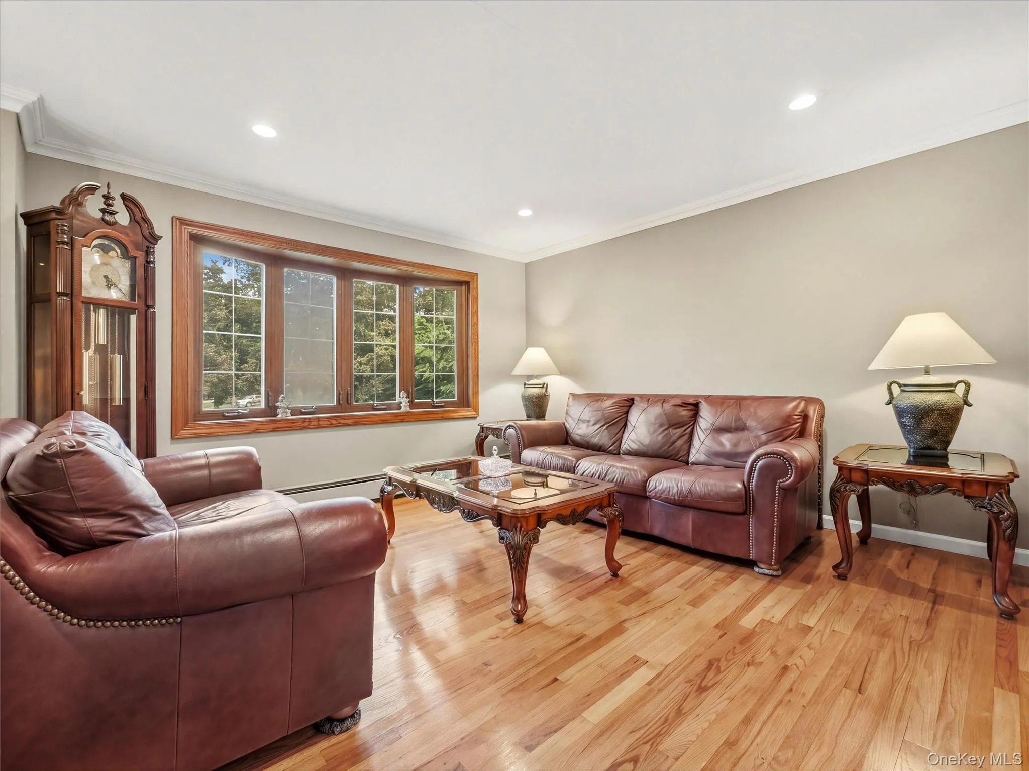 Bay window with wood trim, recessed lighting, wood-finish flooring, and crown molding Bay window with wood trim, recessed lighting, wood-finish flooring, and crown molding
