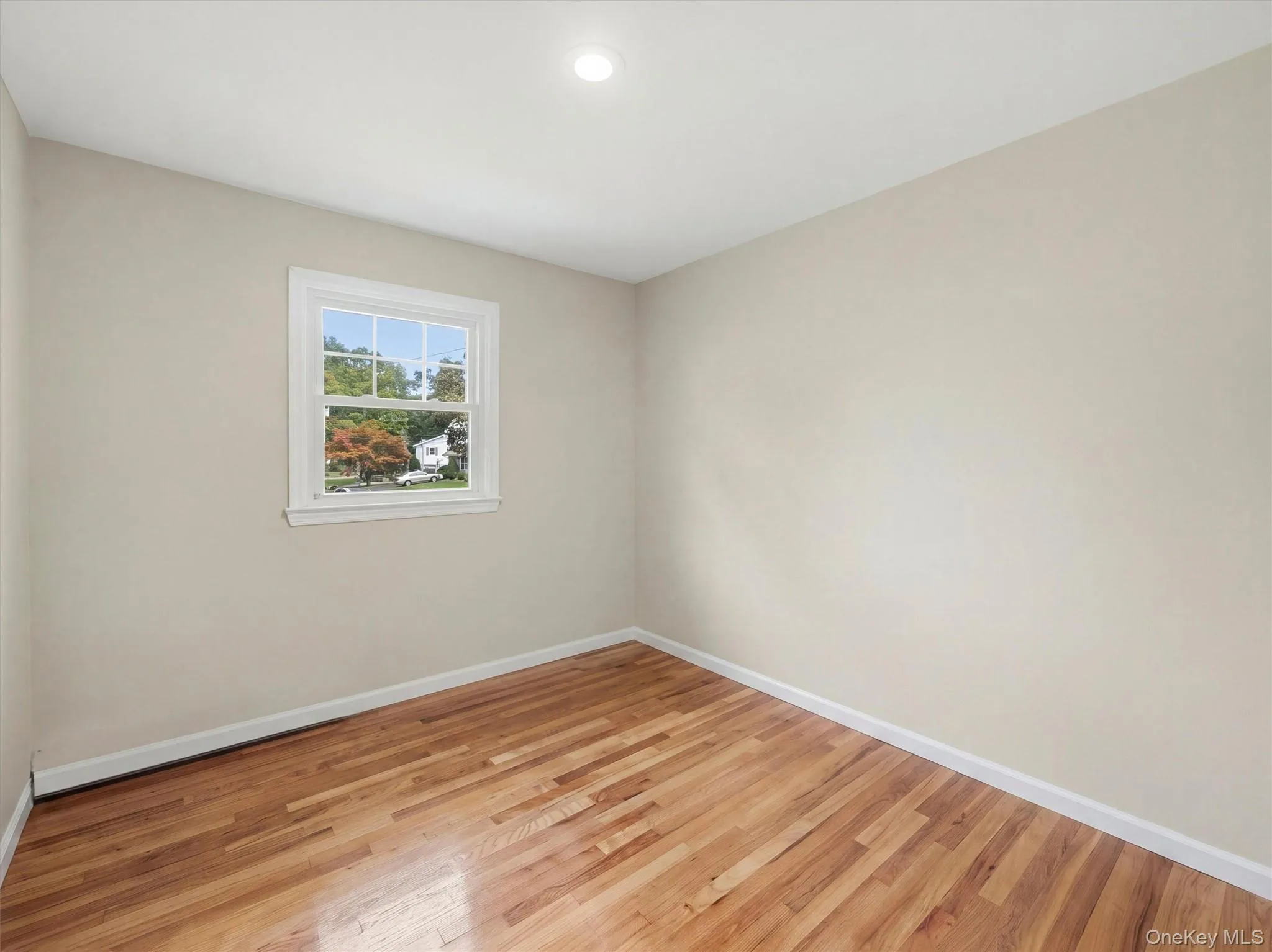 Neutral wall tones, recessed lighting, white trim, and a window with white framing Neutral wall tones, recessed lighting, white trim, and a window with white framing