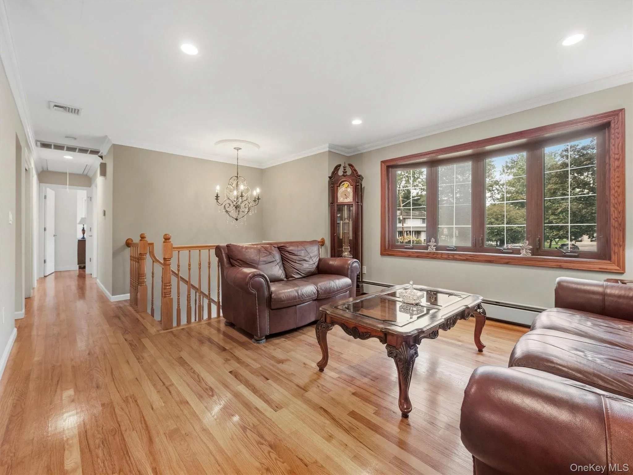 Hardwood flooring throughout, recessed lighting, crown molding, and a bay window with wood trim Hardwood flooring throughout, recessed lighting, crown molding, and a bay window with wood trim