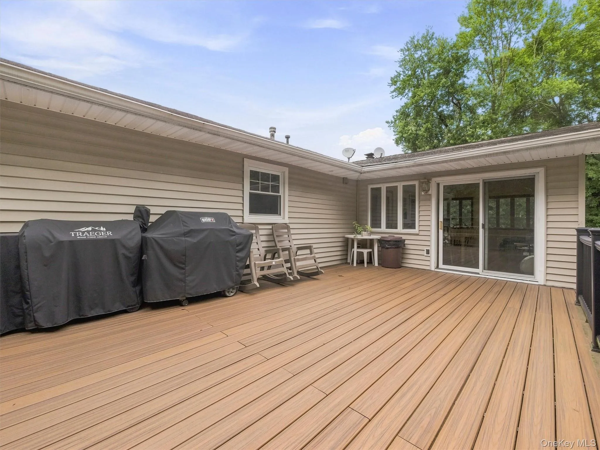 Expansive deck featuring a sliding glass door, multiple windows, and a railing system Expansive deck featuring a sliding glass door, multiple windows, and a railing system